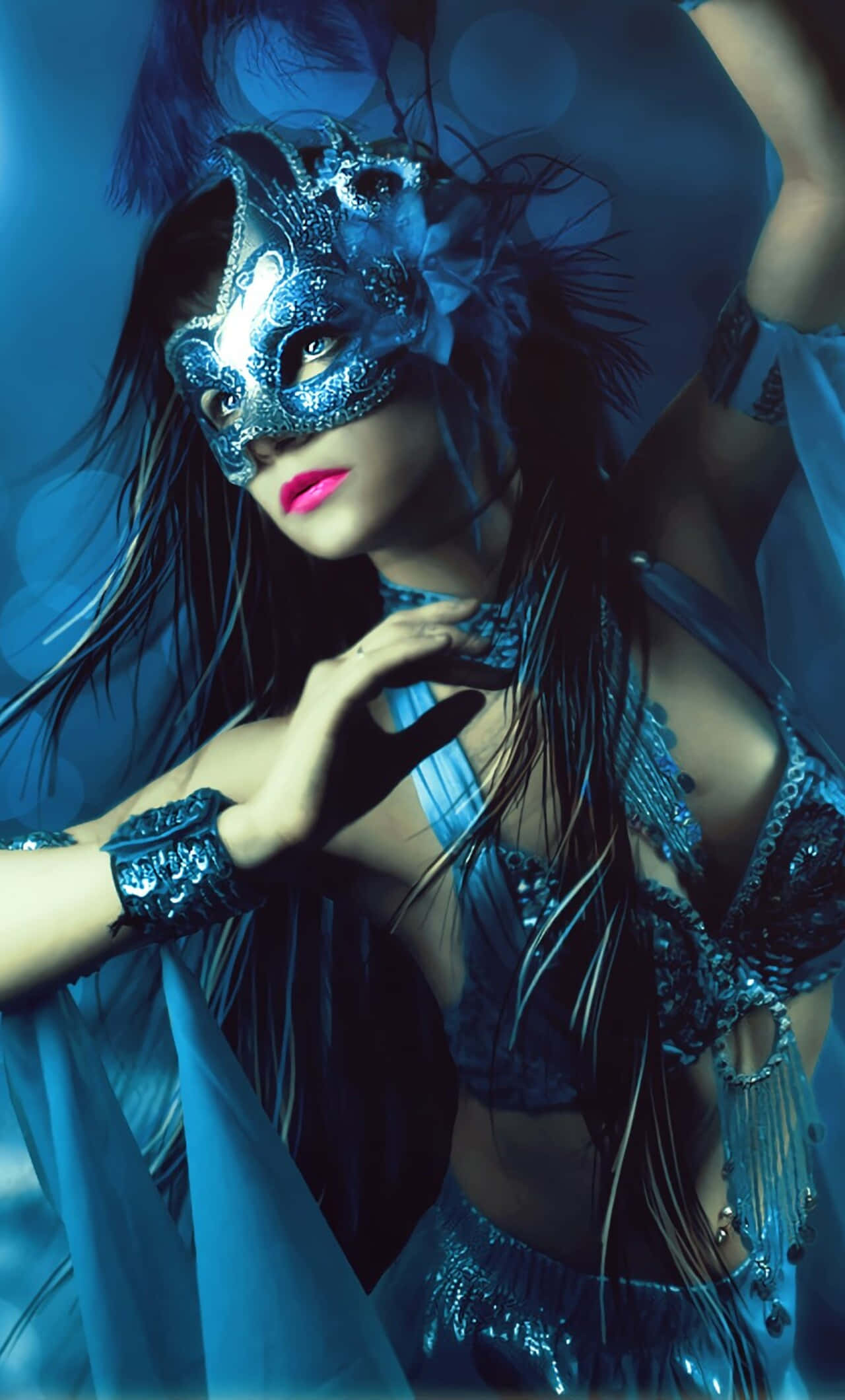 Halloween Masks 桌布 壁紙 — 一位女士戴著華麗的藍色化妝舞會面具和相配的服裝，在模糊的藍色背景下戲劇性地擺姿勢。