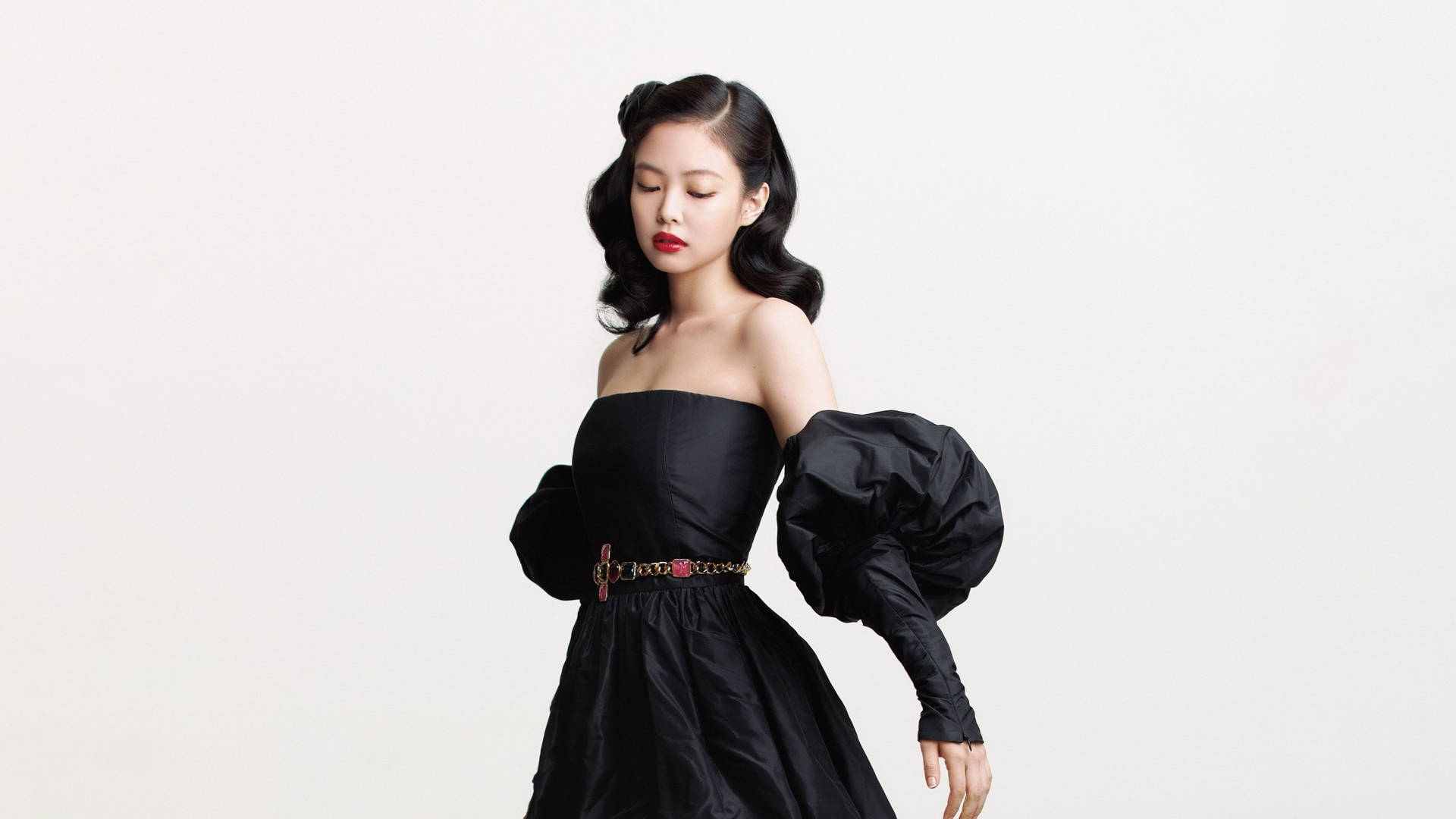 身穿黑色泡泡袖連衣裙和紅色唇膏的女性在攝影棚擺姿勢。 — Blackpink 壁紙