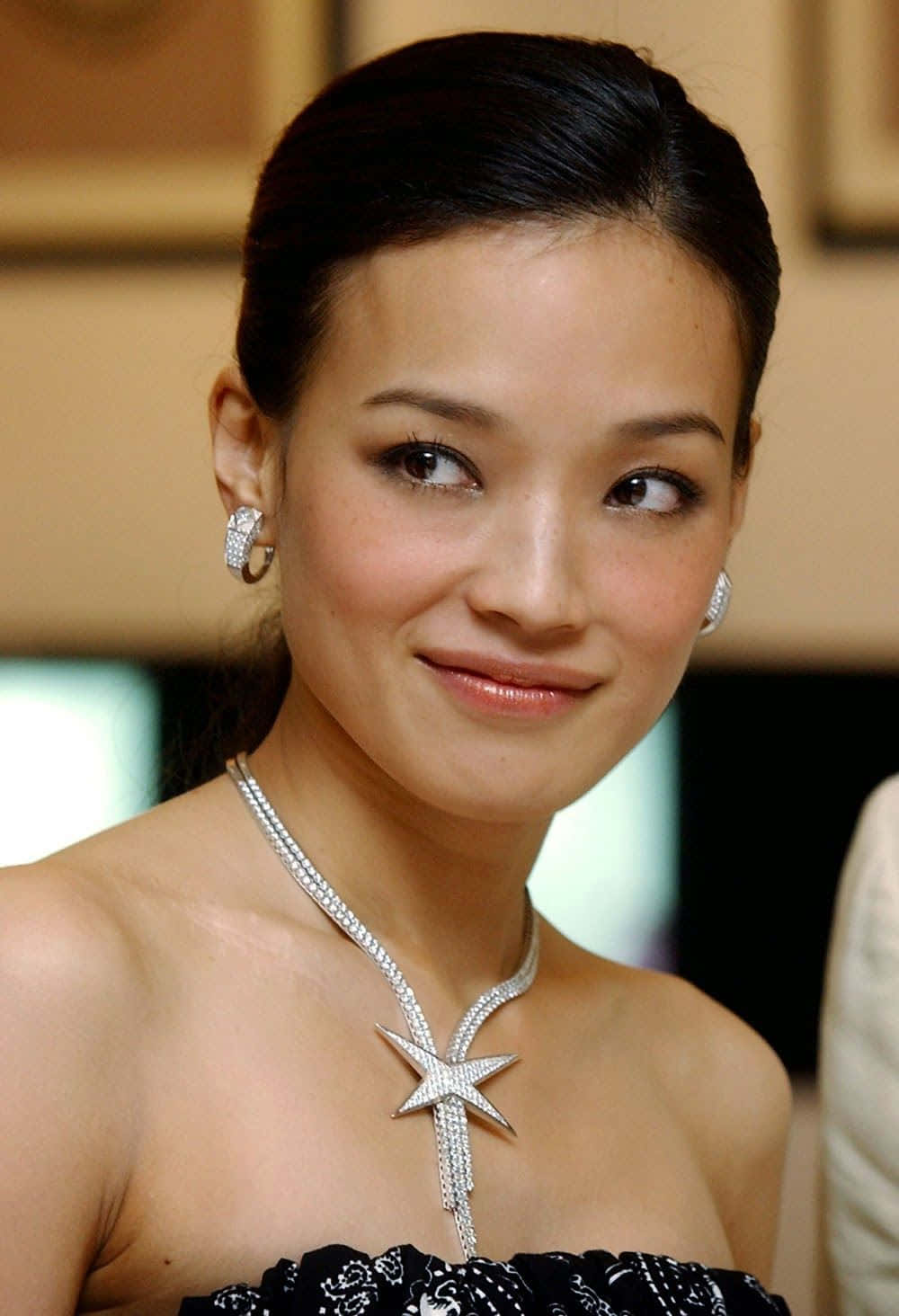 Shu Qi 桌布 壁紙 — 一位深色頭髮向後梳理的女性，戴著閃閃發光的鑽石星形項鍊和配套耳環，溫柔地微笑。