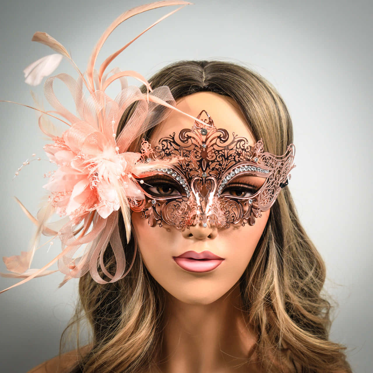 Halloween Masks 桌布 壁紙 — 一位女士戴著華麗的蜜桃色化妝舞會面具，飾有羽毛和蕾絲，背景為柔和的灰色。