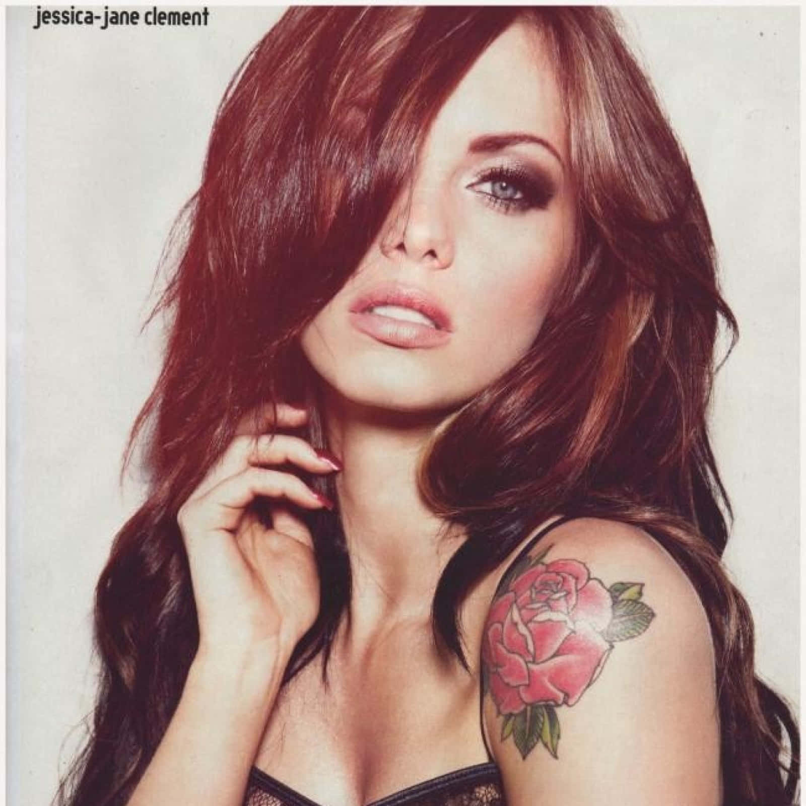 Jessica Jane Clement 桌布 壁紙 — 一位擁有長棕髮和肩上玫瑰刺青的女性，直視鏡頭，露出一隻眼睛。