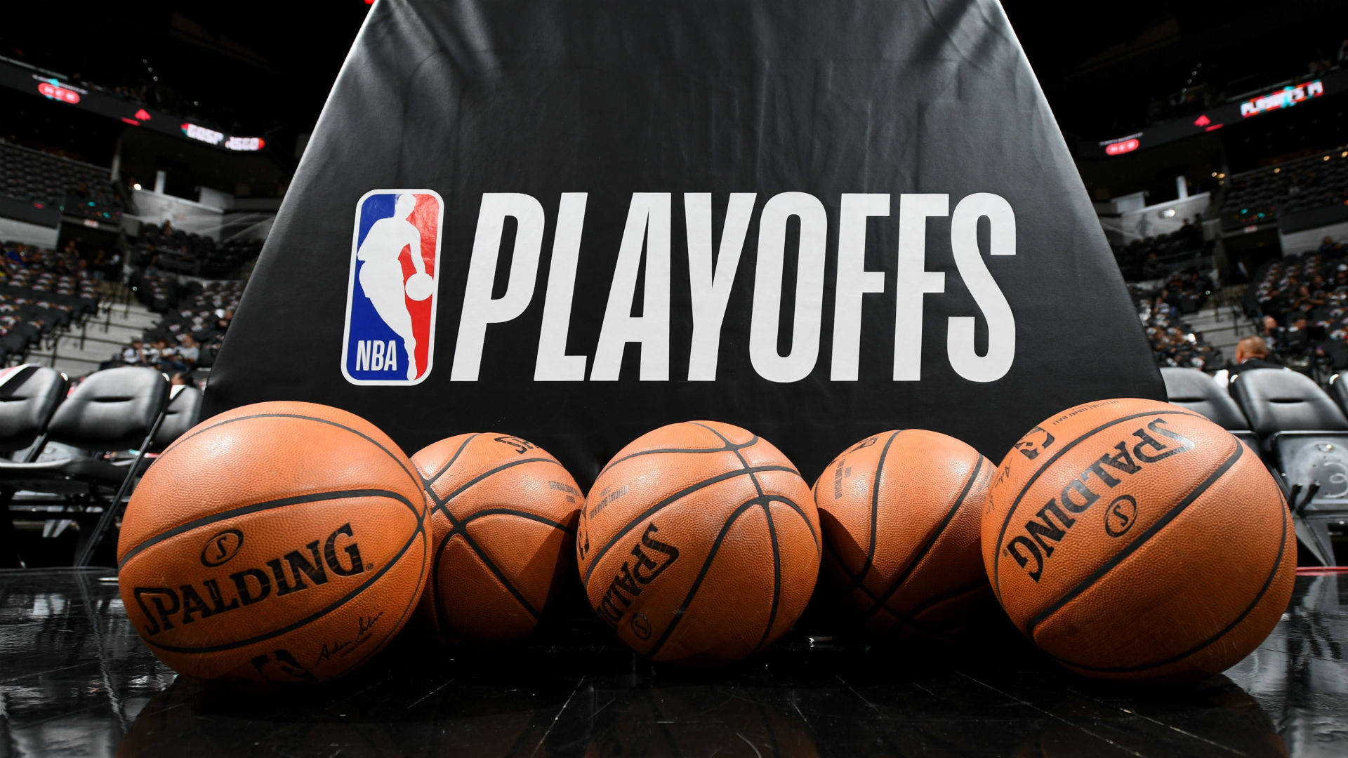 體育館內 NBA 季後賽橫幅前的五個籃球。