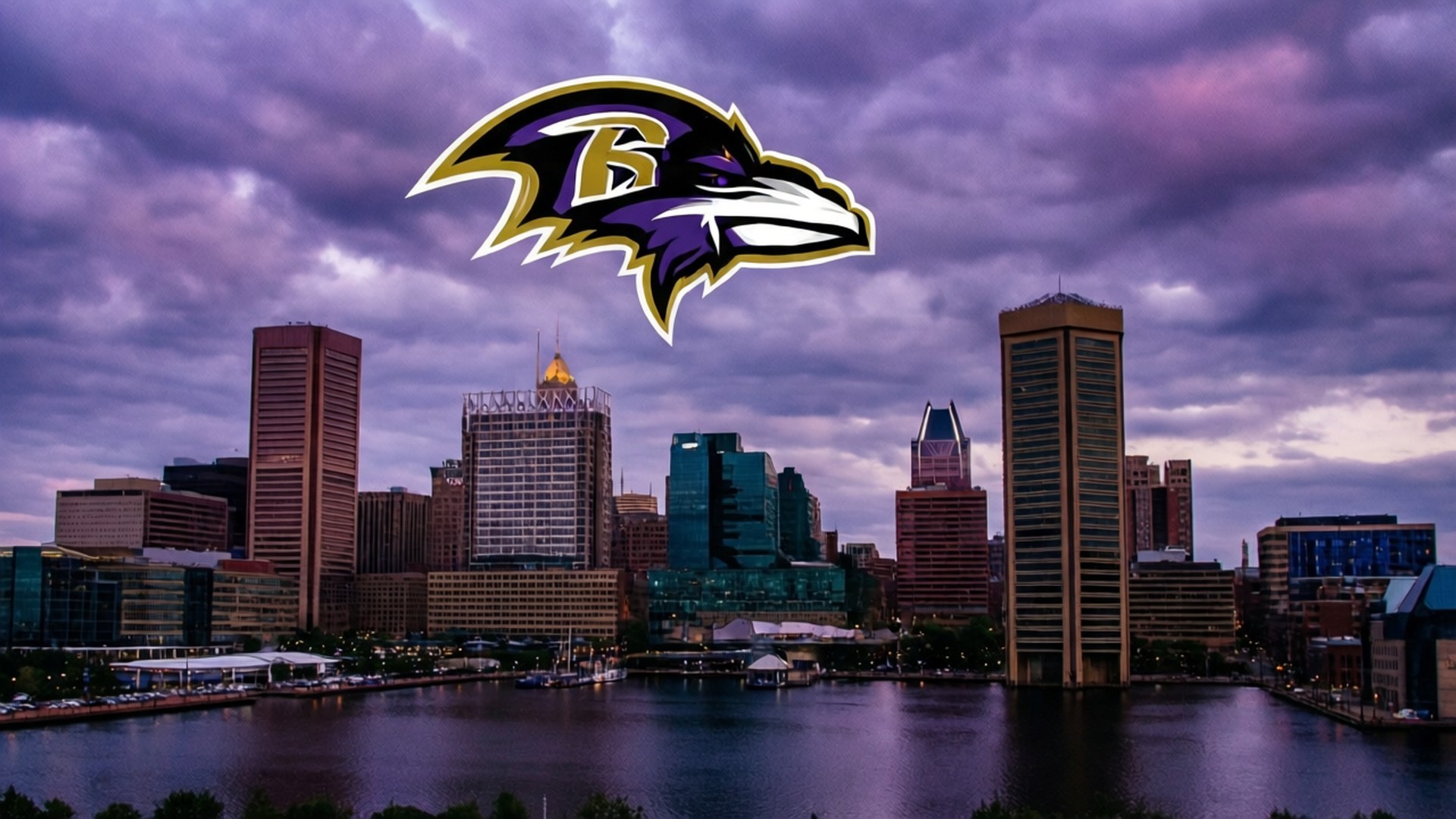 Ravens Over Baltimore 壁紙 — 烏鴉隊標誌漂浮在巴爾的摩天際線上方，暮色中帶有紫色雲彩和下方反射的水面。