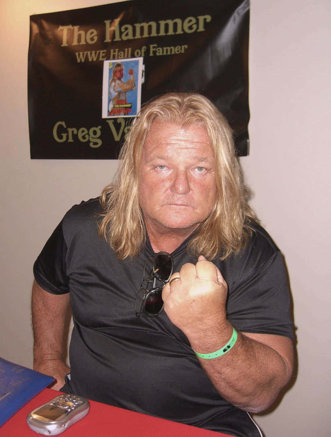 WWE 桌布 壁紙 — WWE名人堂成員Greg Valentine在簽名活動中，在入選橫幅前握拳擺姿勢。