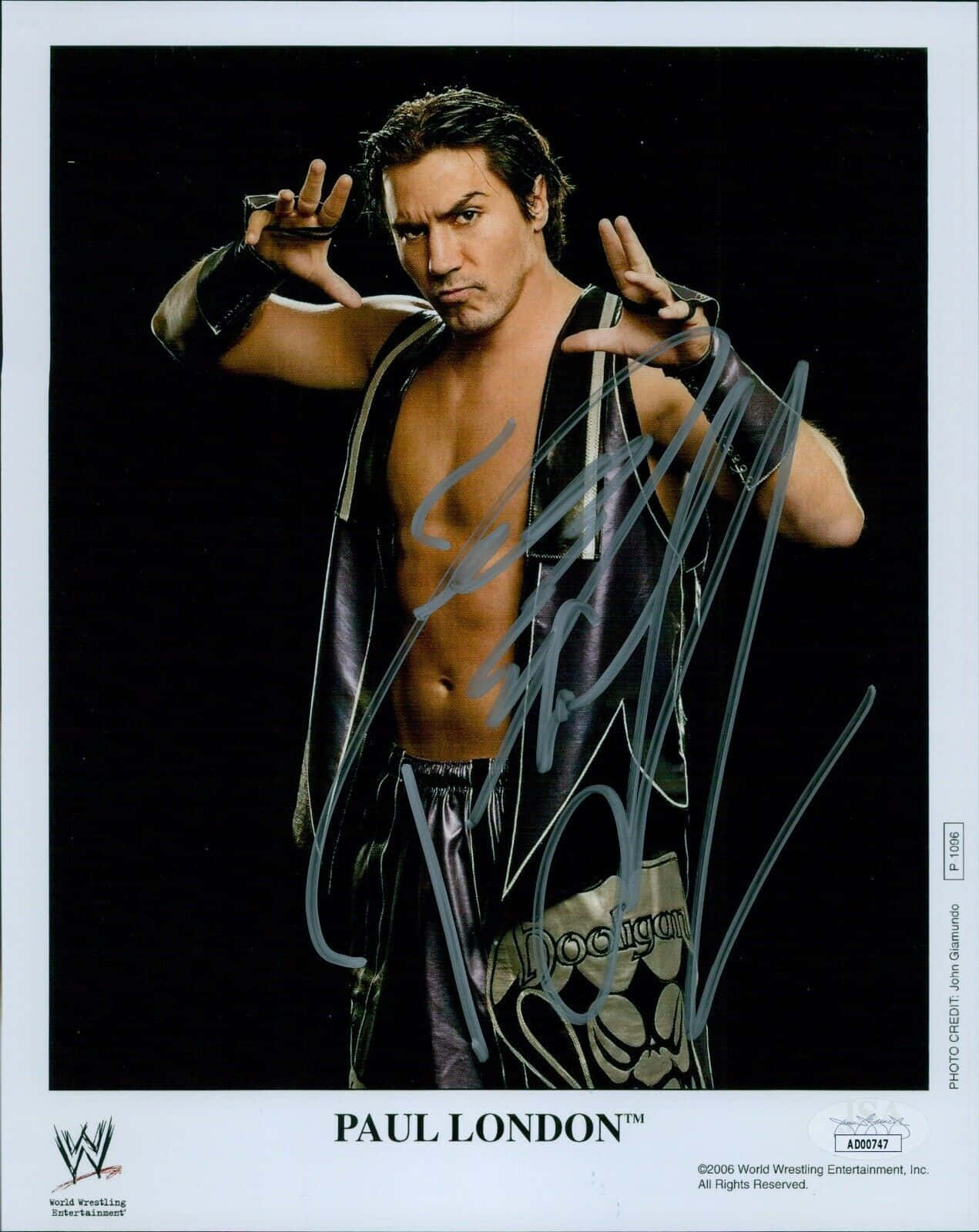 actor 桌布 壁紙 — WWE摔角手Paul London自信地擺姿勢，身穿閃亮黑色背心，背景深色，照片上橫跨他的簽名。