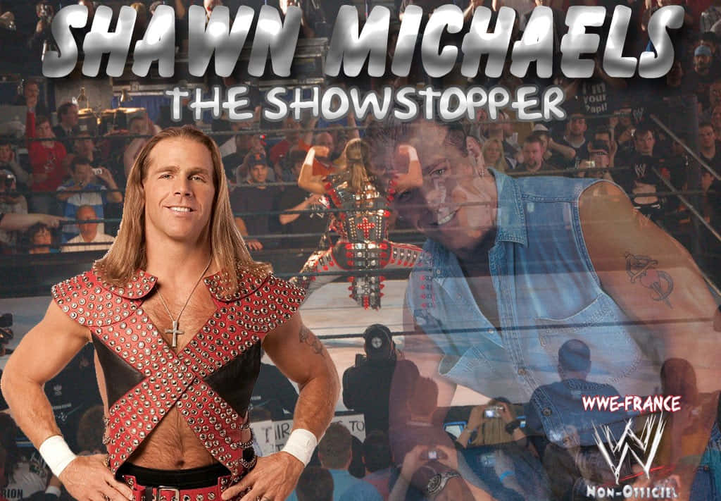 shawn michaels 桌布 壁紙 — WWE摔角手Shawn Michaels自信地擺姿勢，身穿飾有鉚釘的紅色背心，背景有群眾和擂台。