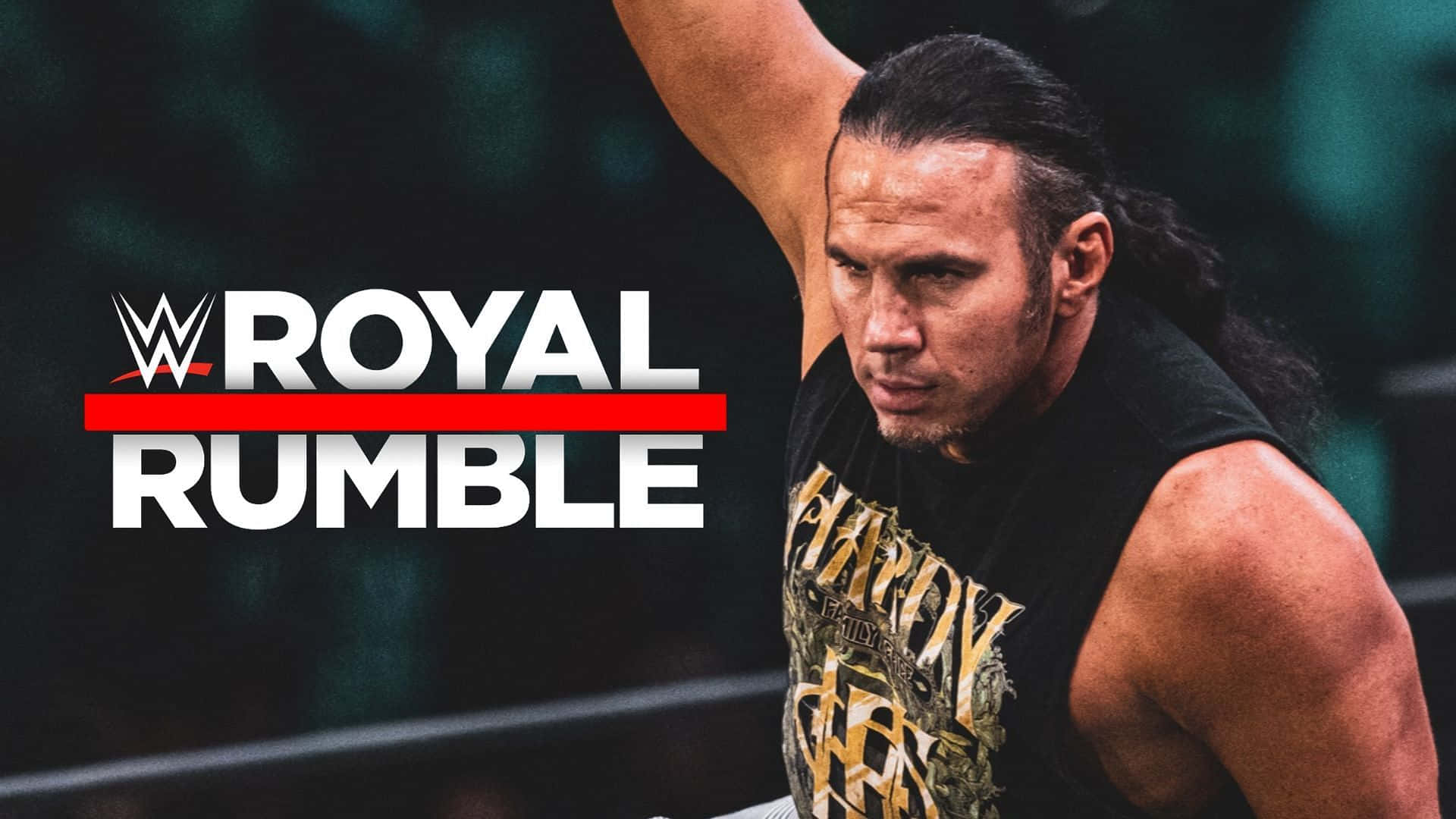 WWE 桌布 壁紙 — WWE摔角手留著長黑髮，在明亮的場館燈光下，於帶有 'Royal Rumble' 標誌的摔角擂台上舉起手臂。