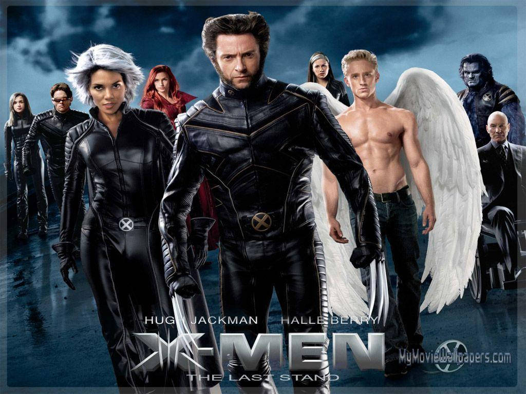 X 桌布 壁紙 — X-Men 團隊英勇地站在黑暗的暴風雨中，金鋼狼在前，天使的白色翅膀張開。