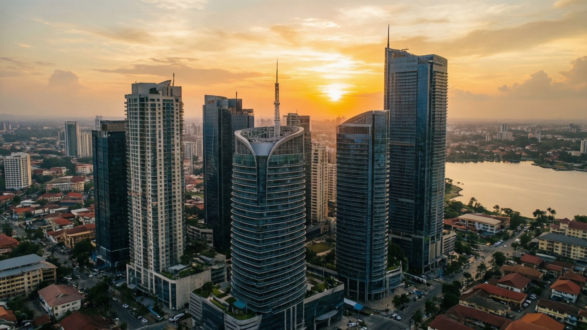 Lagos Sunset Skyline 壁紙 — 夕陽從空中俯瞰，將現代摩天大樓和寧靜的河流沐浴在金色光芒中。