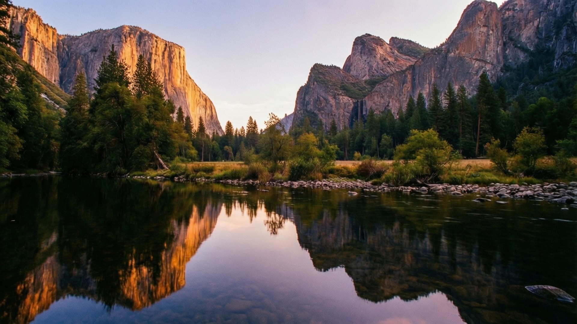 El Capitan Sunset Reflection 壁紙 — 夕陽將花崗岩懸崖和松樹沐浴在金色光芒中，完美地倒映在平靜的河流中。