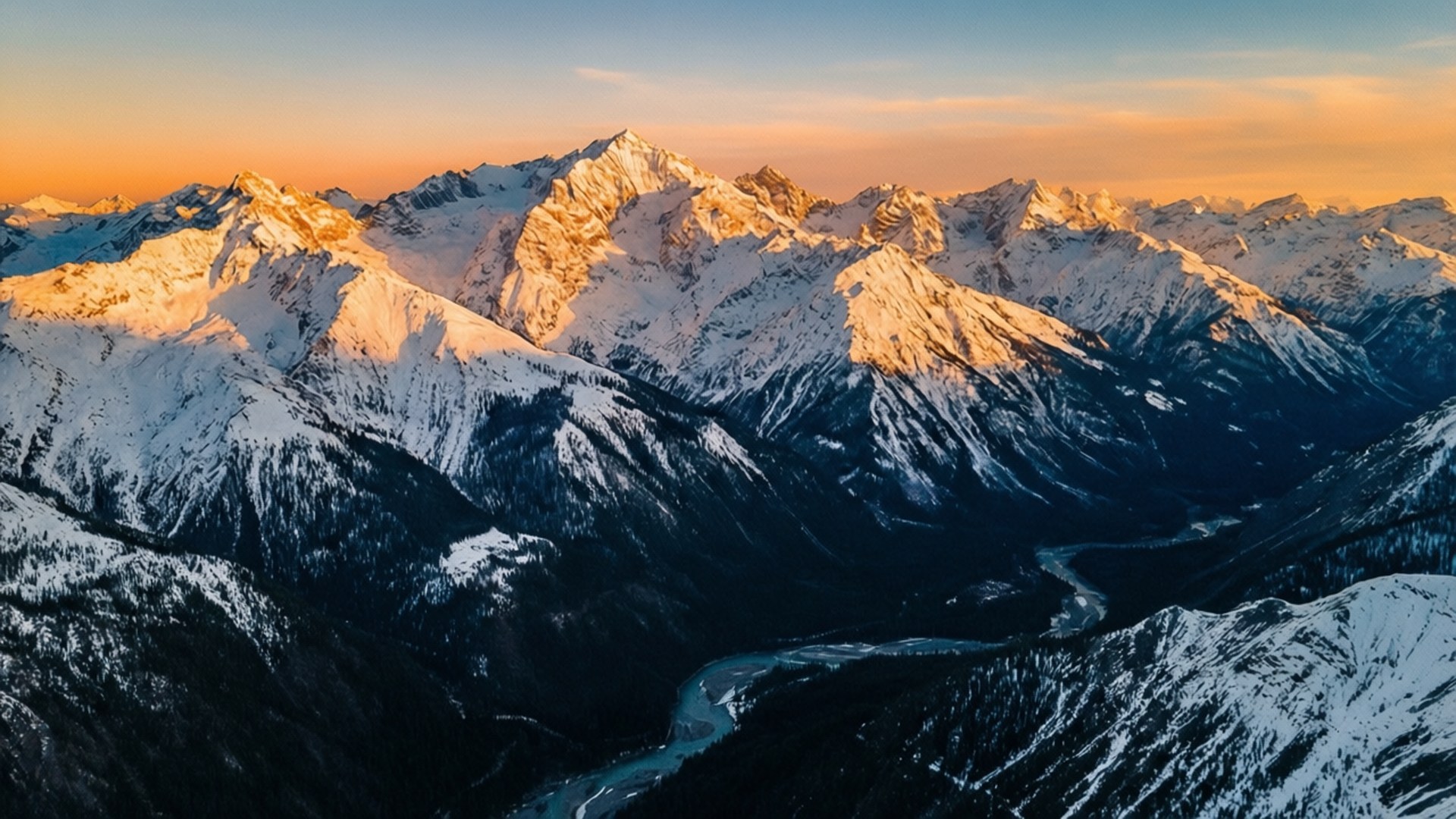Golden Hour Range 壁紙 — 夕陽將積雪的山峰染成金色，蜿蜒的河流穿過下方的山谷。