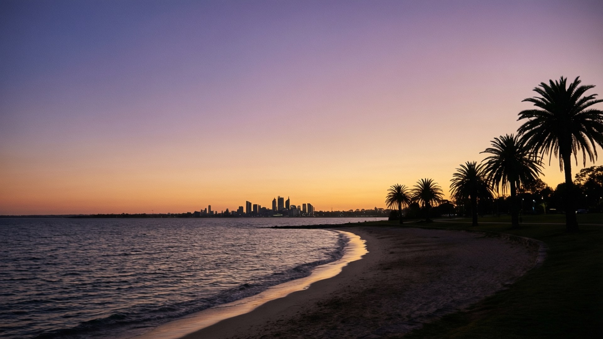 West Beach Skyline Distant 壁紙 — 夕陽將天空染成紫色、橙色和金色，海浪拍打著沙灘，沙灘上種有棕櫚樹，遠處是城市天際線。