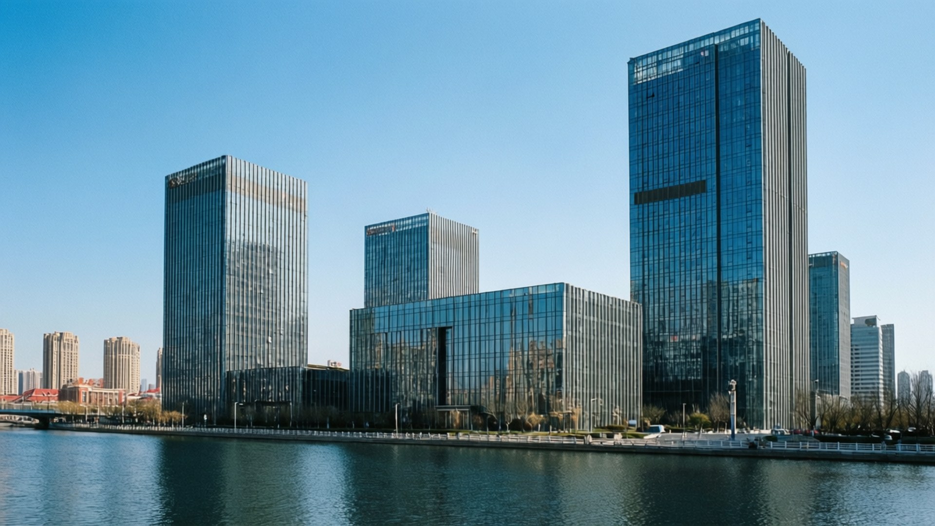 Riverside Modern Glass 壁紙 — 現代玻璃摩天大樓倒映藍天碧水，營造出時尚的城市海濱場景。