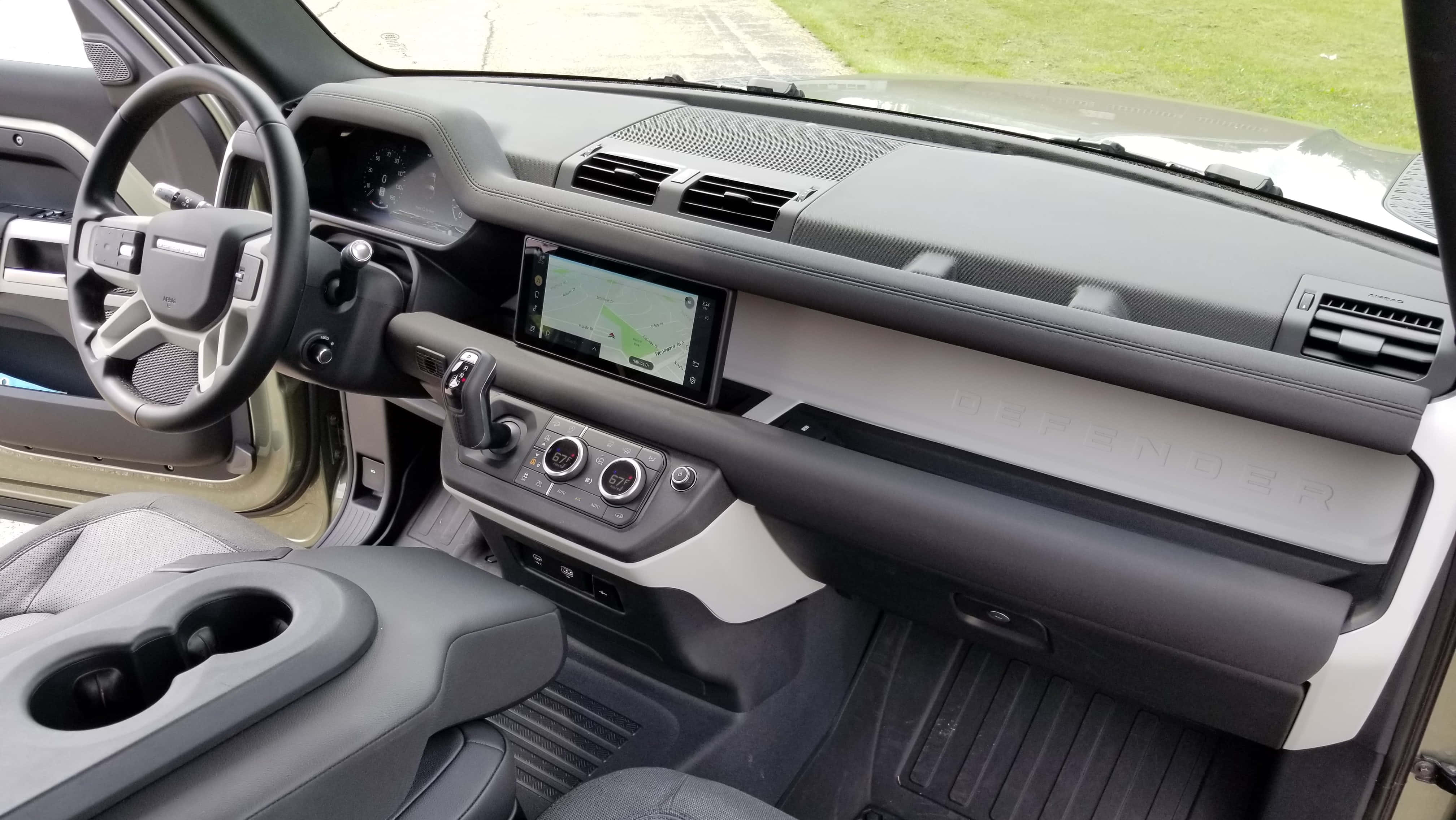 Land Rover Defender 桌布 壁紙 — 現代路虎衛士內飾特寫展示黑色方向盤、中控螢幕和灰色皮革座椅
