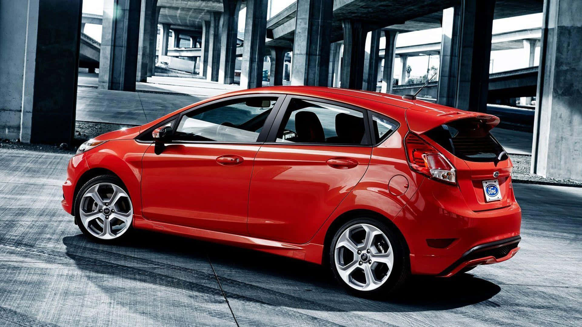 Ford Fiesta 桌布 壁紙 — 一輛鮮紅色的福特 Fiesta 掀背車停放在混凝土高架橋下，周圍有工業支柱和灰色路面。