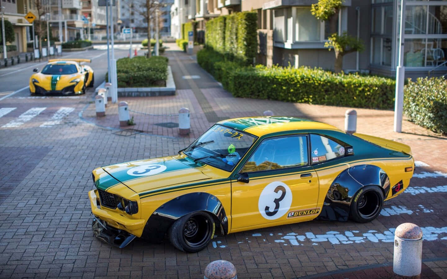 Mazda Rx-3 桌布 壁紙 — 一輛鮮黃色和綠色的改裝賽車，車號三，停放在住宅區的磚街上。