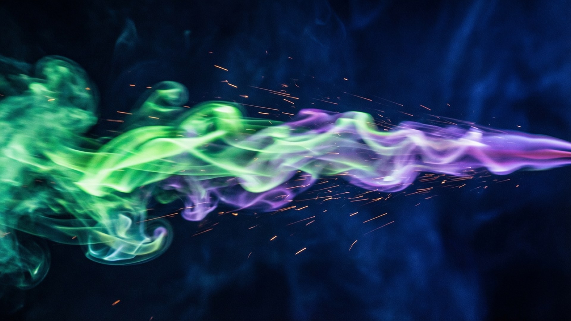 Neon Speed Streak 壁紙 — 鮮豔的綠色和紫色煙霧斜向穿過深藍色背景，帶有發光的橙色火花。