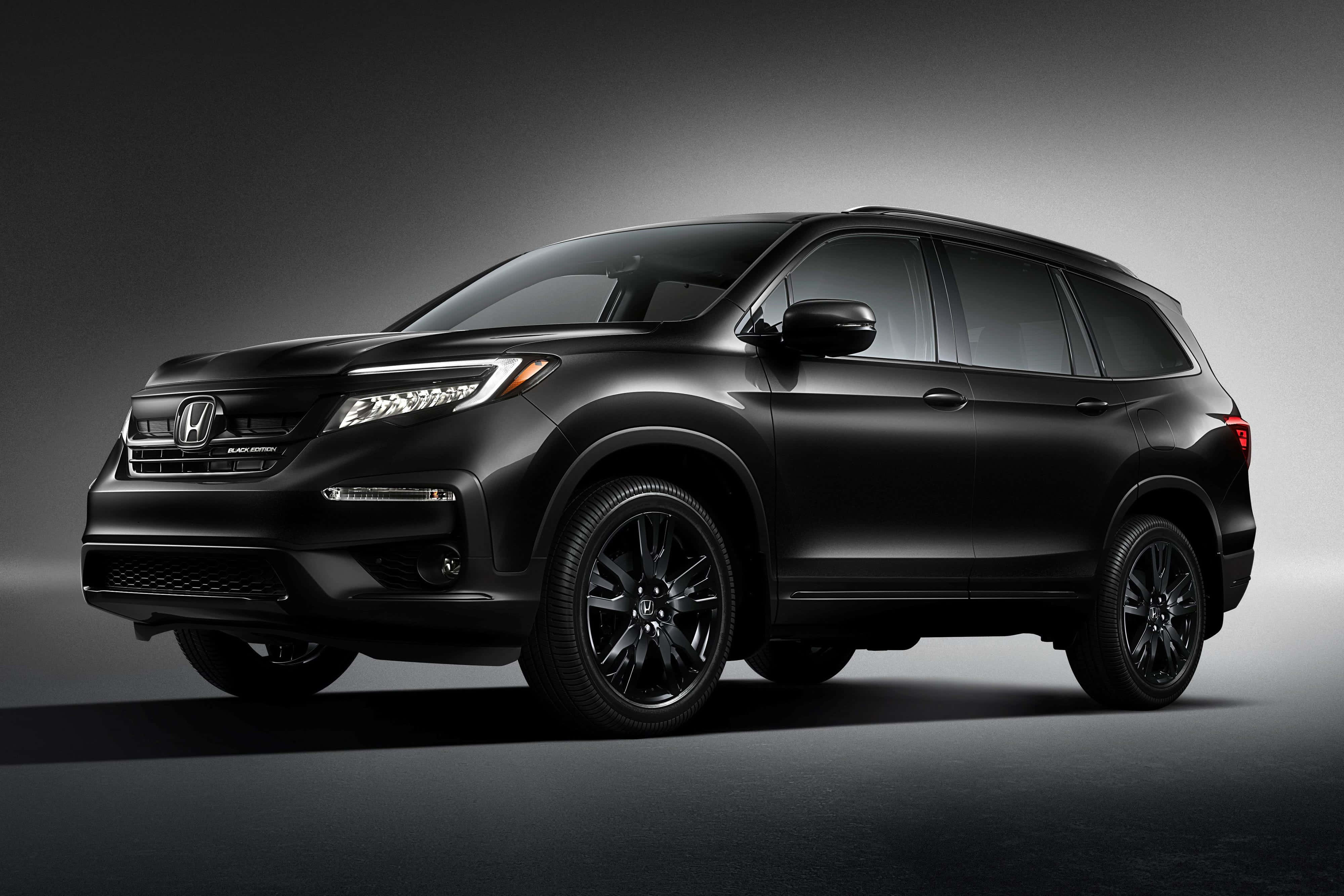 Honda Pilot 桌布 壁紙 — 在工作室中展示的時尚消光黑色本田Pilot SUV，配以戲劇性燈光和漸變灰色背景。