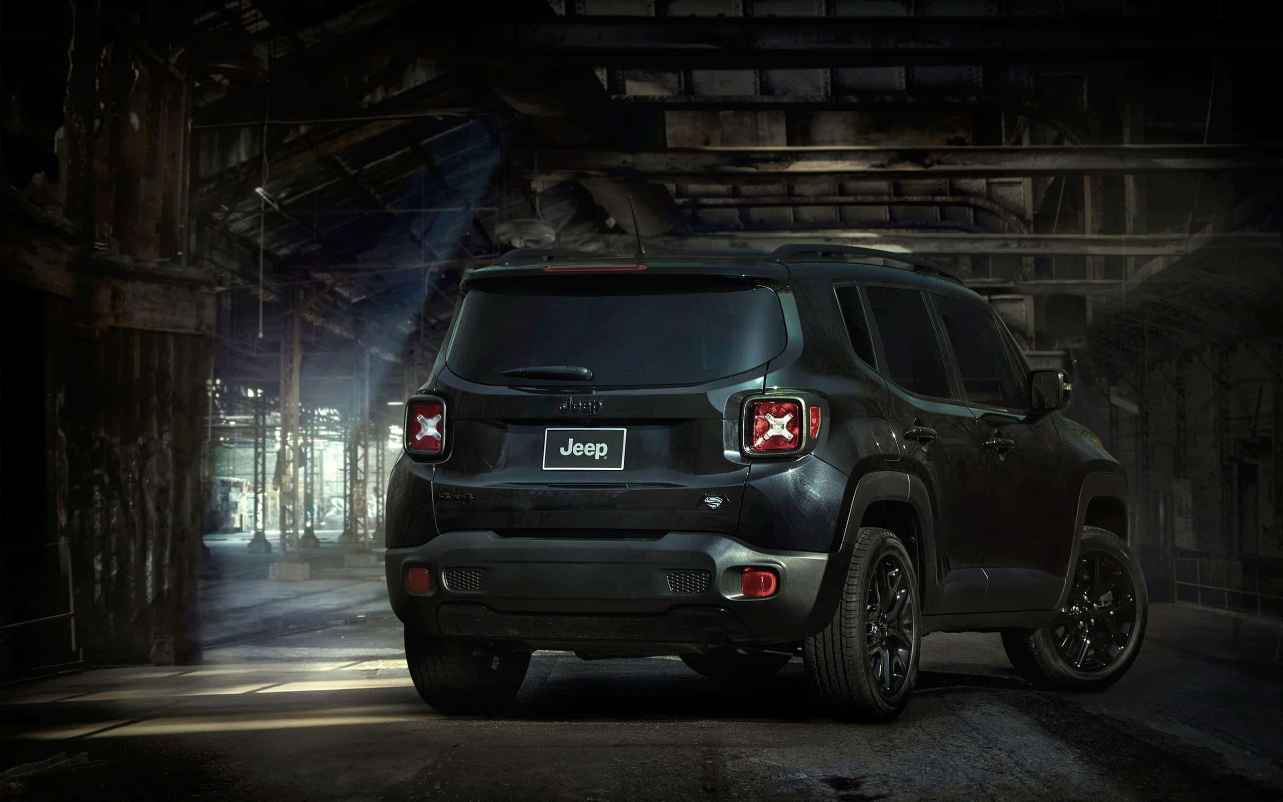 Jeep Renegade 桌布 壁紙 — 一輛消光黑色Jeep Renegade停放在光線昏暗的廢棄倉庫中，戲劇性的光束穿過灰塵。