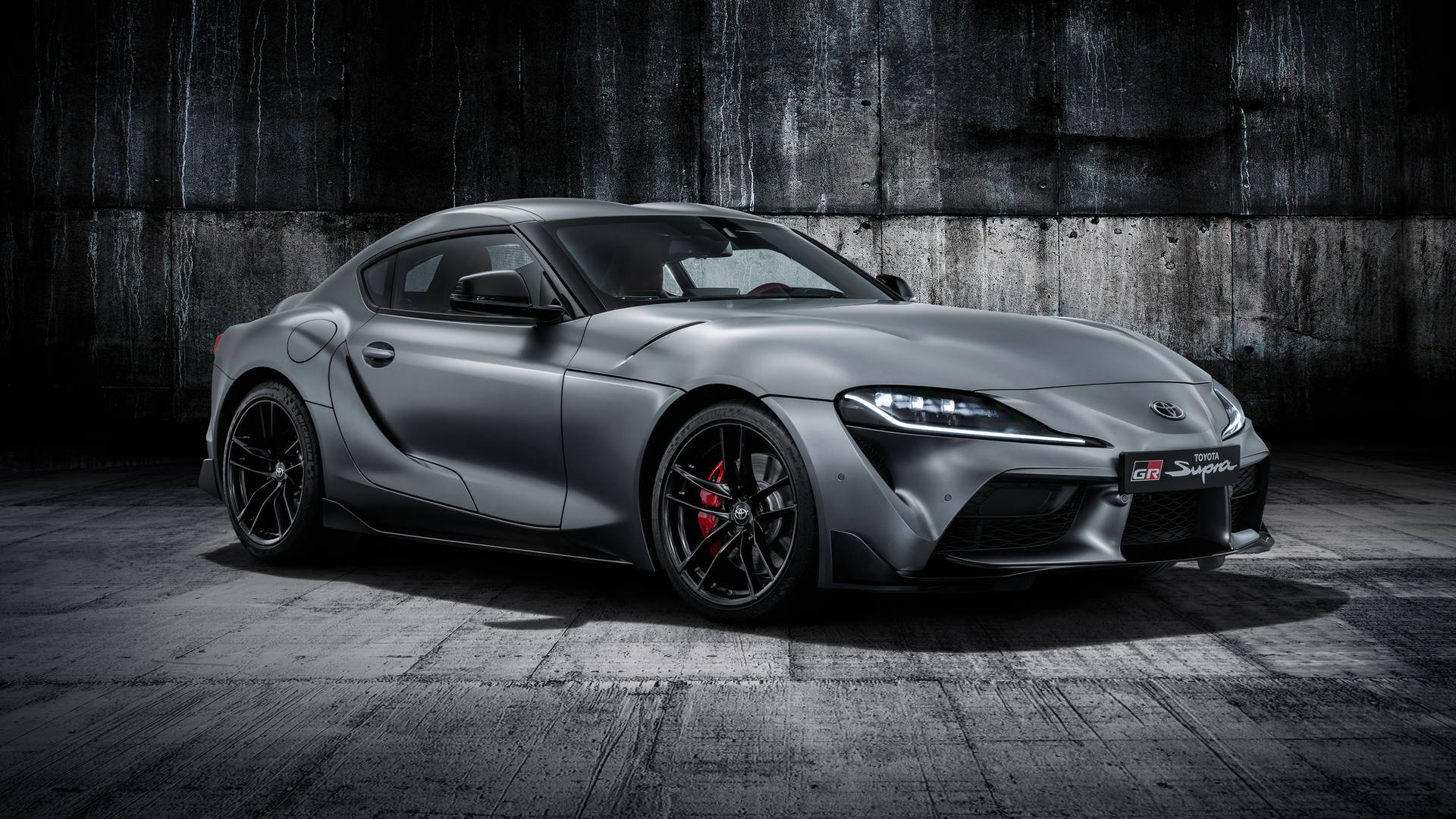 消光灰色豐田GR Supra，紅色制動器，停在混凝土車庫中。 — Toyota Supra 壁紙