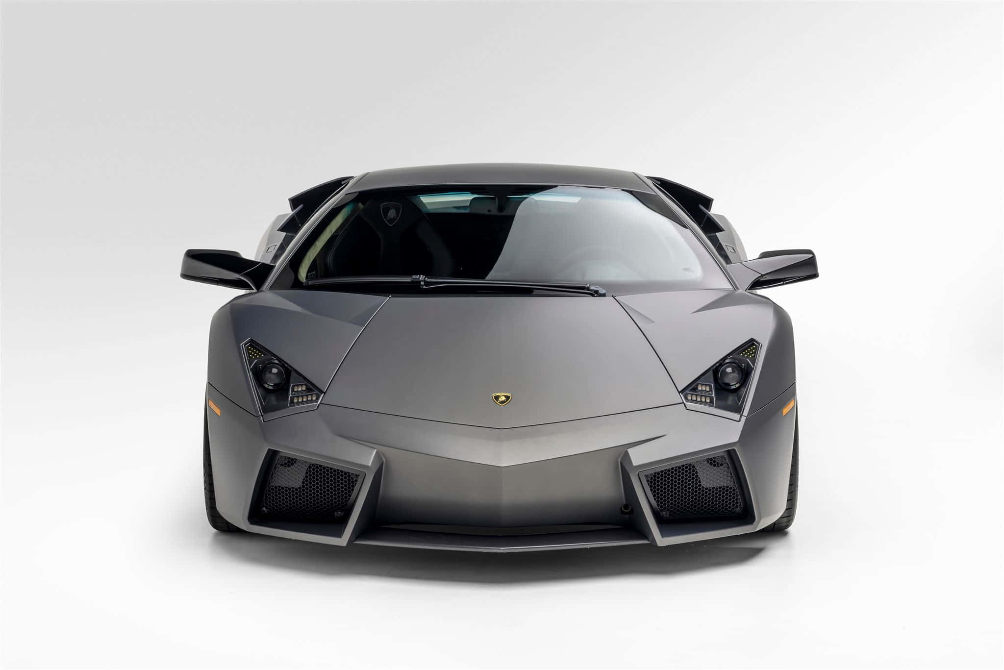 Lamborghini Reventón 桌布 壁紙 — 一輛消光灰色的藍寶堅尼Reventon跑車在純白攝影棚背景前正面朝前。