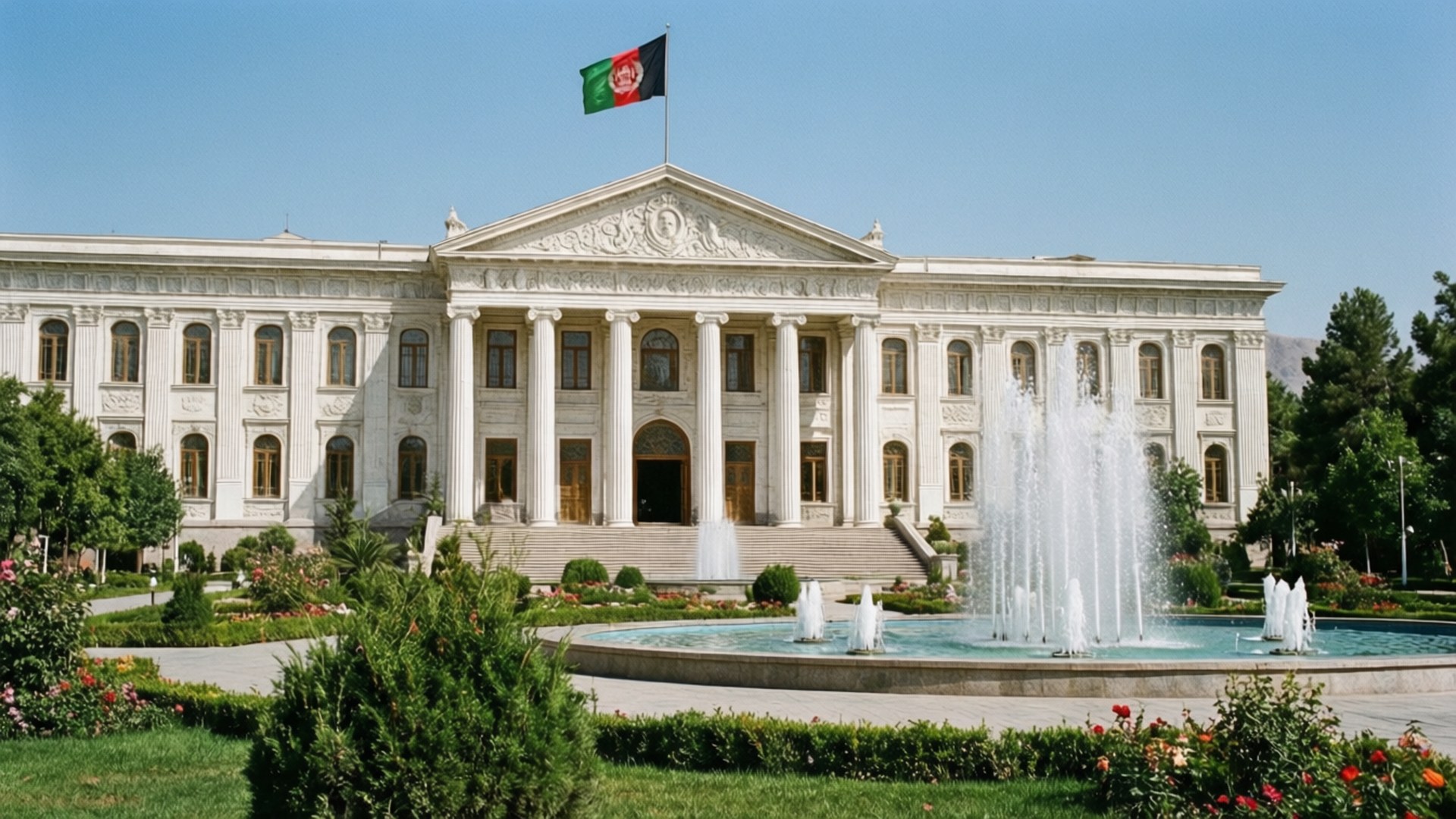 Presidential Palace 壁紙 — 一座新古典主義白色大樓，帶有柱子和屋頂飄揚的旗幟，前方有噴泉和修剪整齊的花園，在晴朗的藍天下。