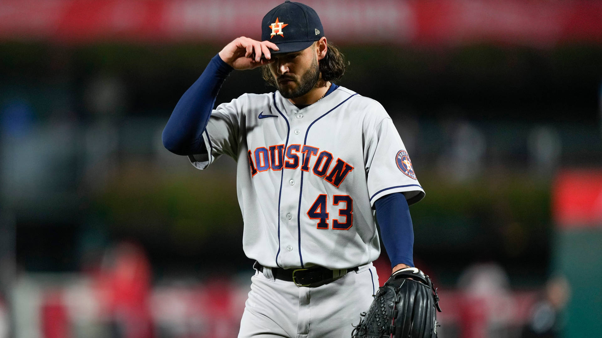 休士頓太空人棒球選手夜晚在球場調整帽子 — MLB 壁紙