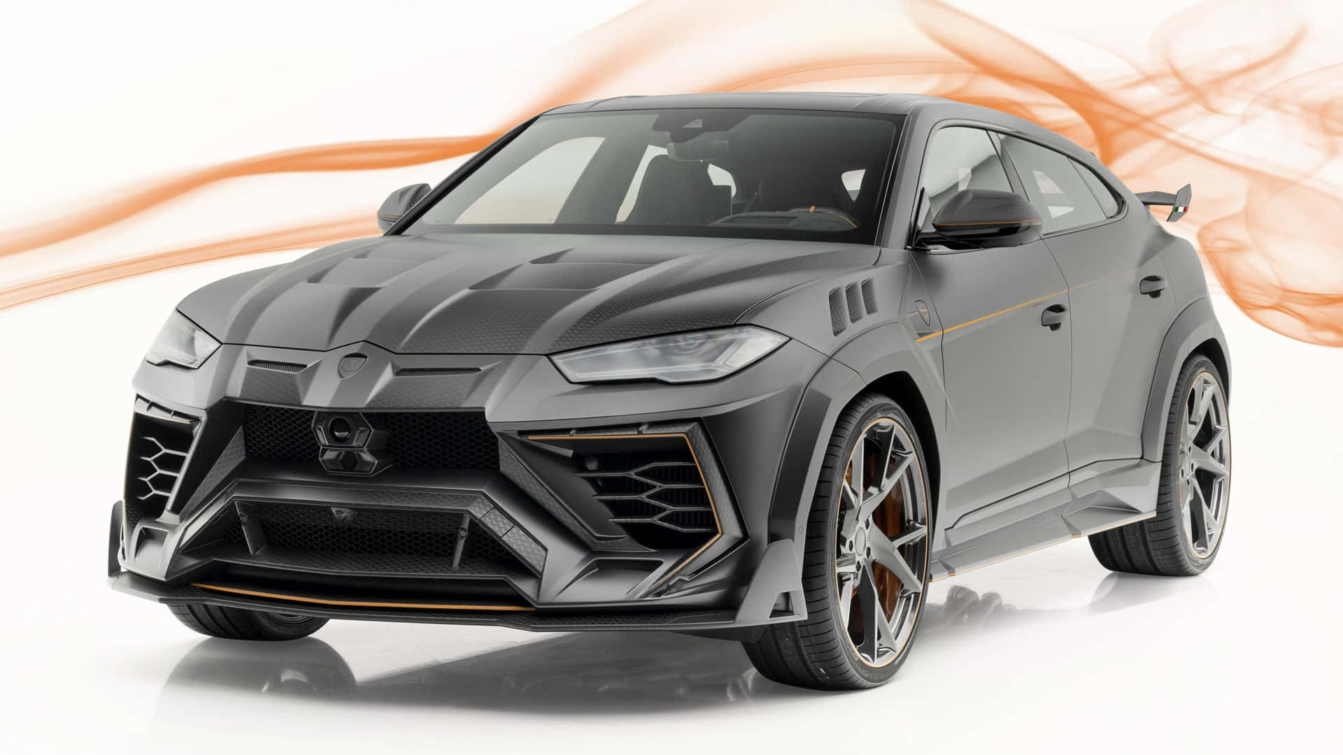Lamborghini Urus 桌布 壁紙 — 啞光灰色藍寶堅尼 Urus，帶橙色點綴和動態煙霧漩渦，在白色攝影棚背景前。