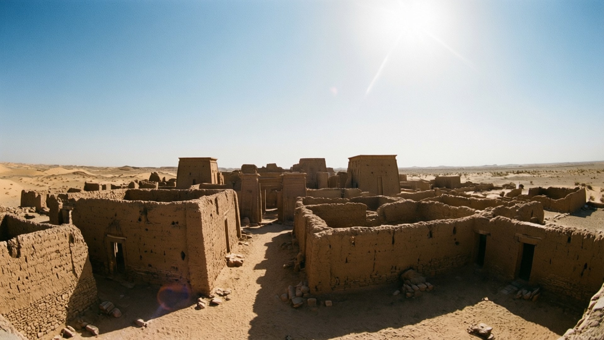 Kerma Ancient City 壁紙 — 陽光普照的沙漠定居點古代泥磚遺址，清澈藍天和明亮鏡頭光暈。