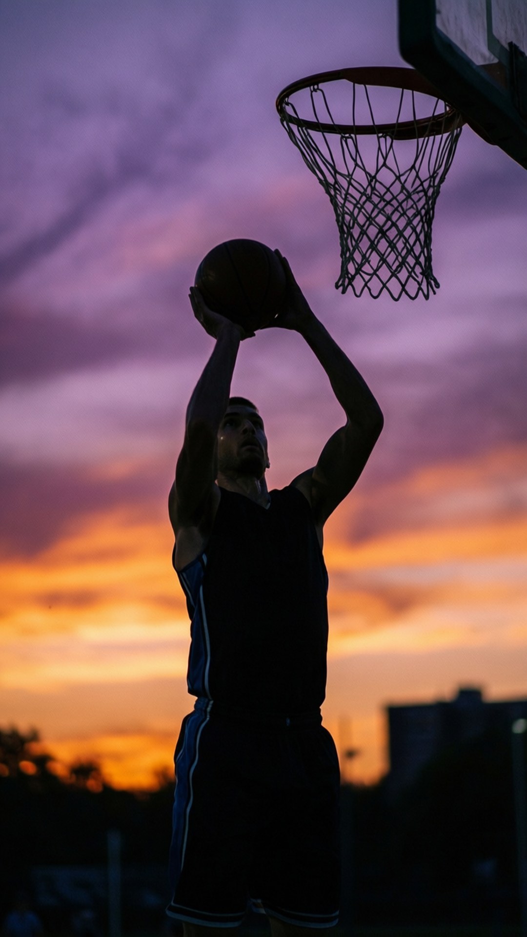 Sunset Shooter Silhouette 壁紙 — 一名籃球運動員在鮮豔的日落背景下以剪影姿態將球灌入籃框。
