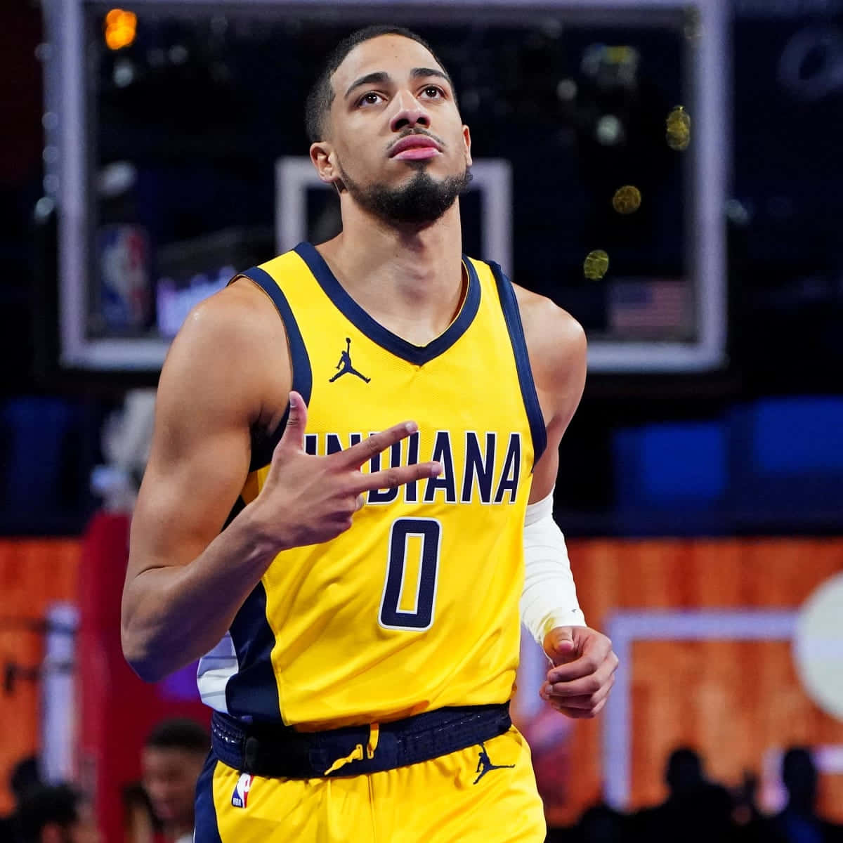 身穿黃色印第安納球衣的籃球運動員在球場上做出和平手勢。 — NBA 壁紙