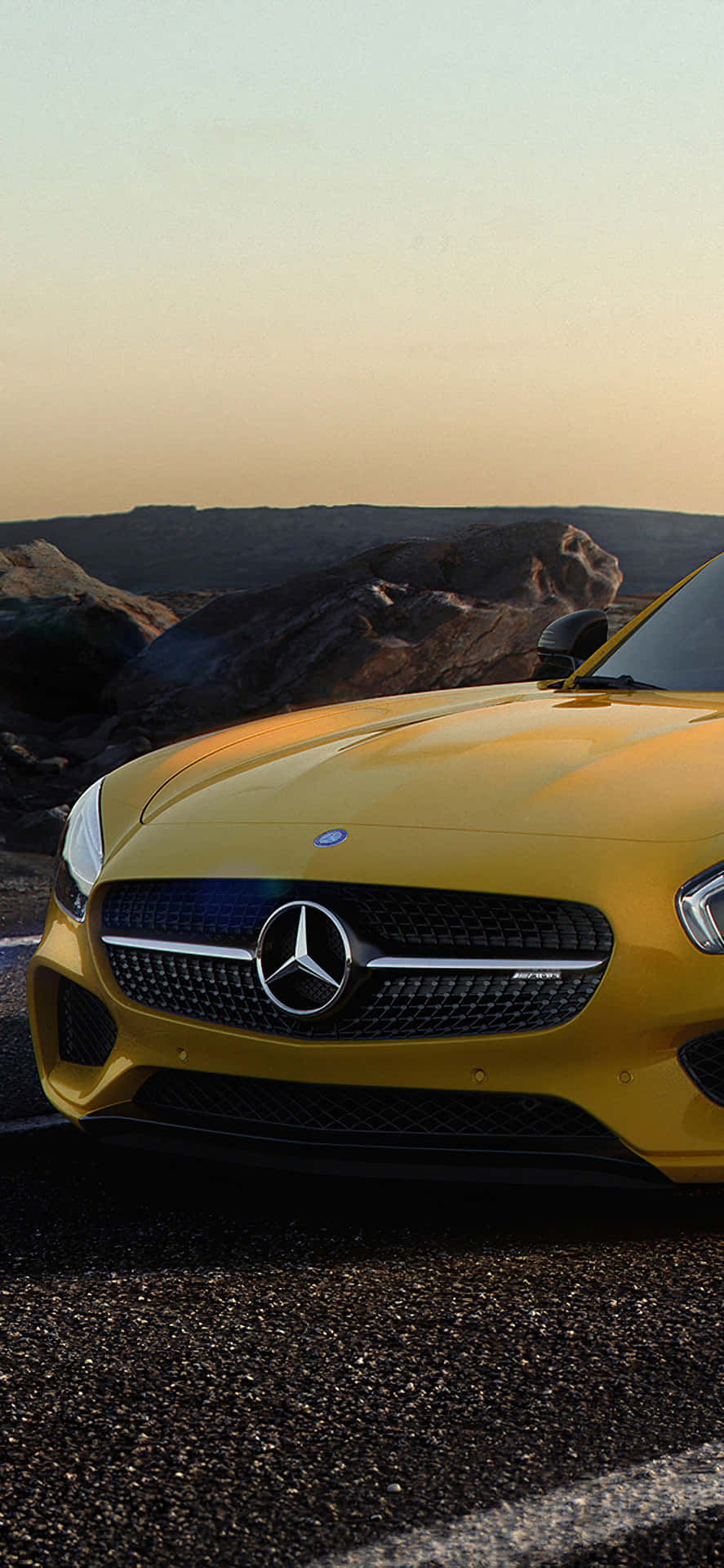 黃色 Mercedes-AMG 跑車停在碎石路上，沙漠日落 — Amg Gt R 壁紙