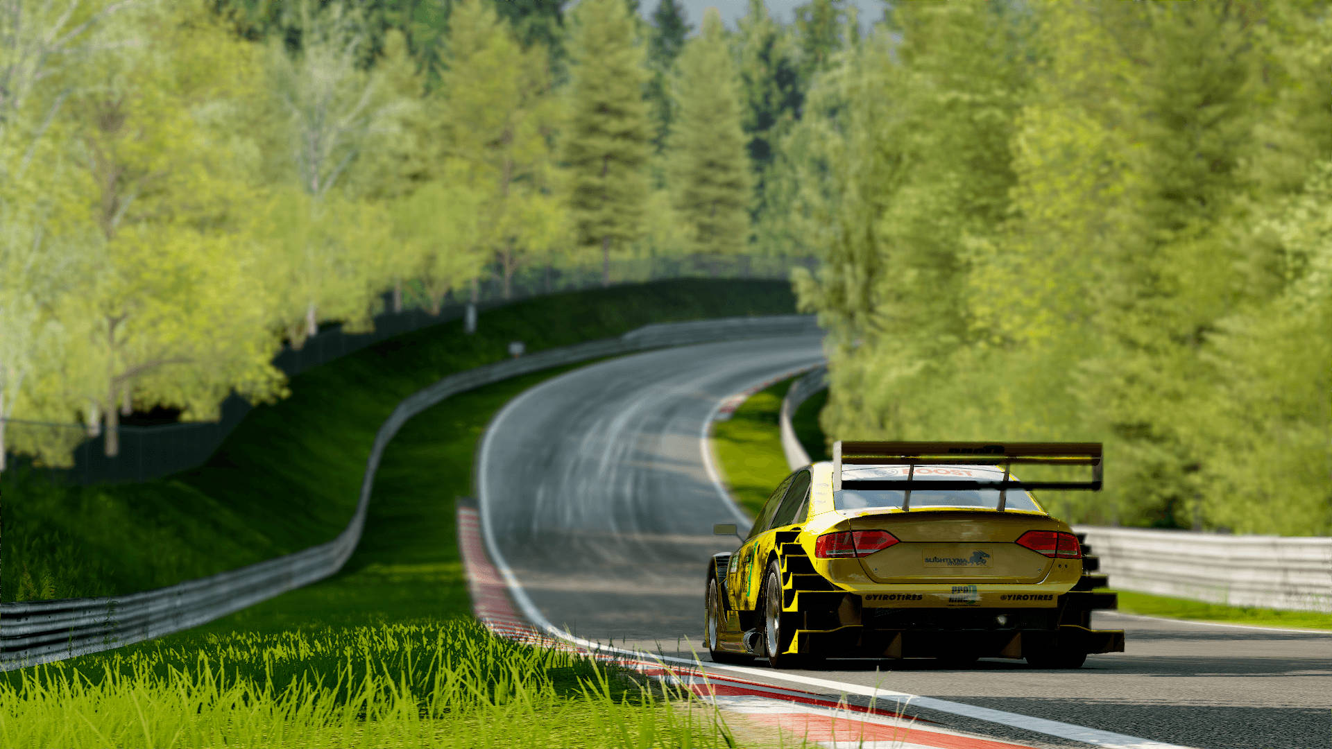 黃色賽車在彎曲的森林賽道上行駛，周圍有綠樹和草地。 — Project Cars 2 壁紙