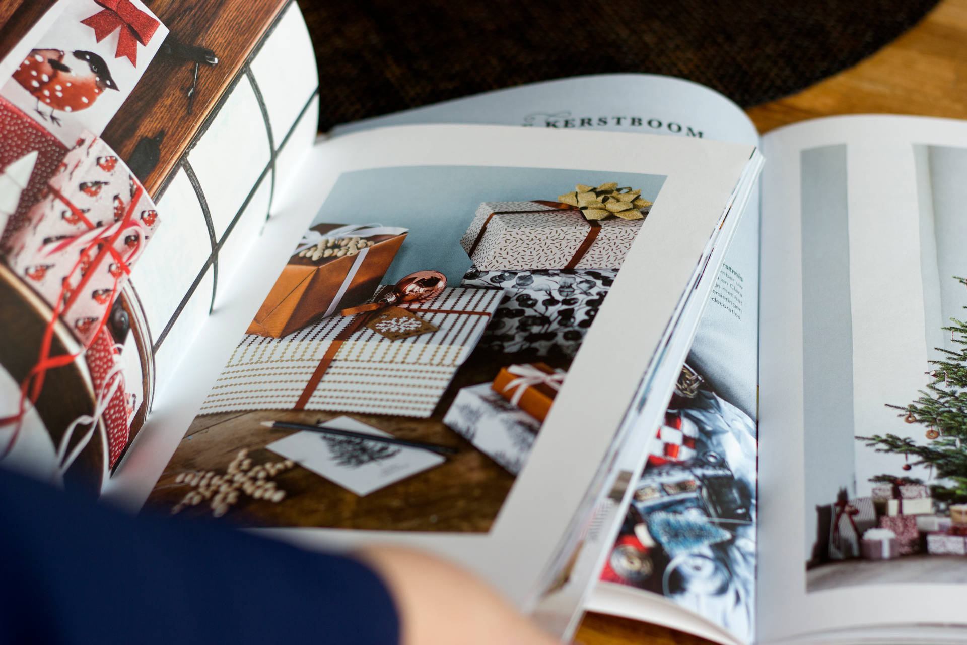 雜誌頁面特寫，展示使用圖案紙和松果的聖誕禮物包裝創意。 — Amoled 壁紙