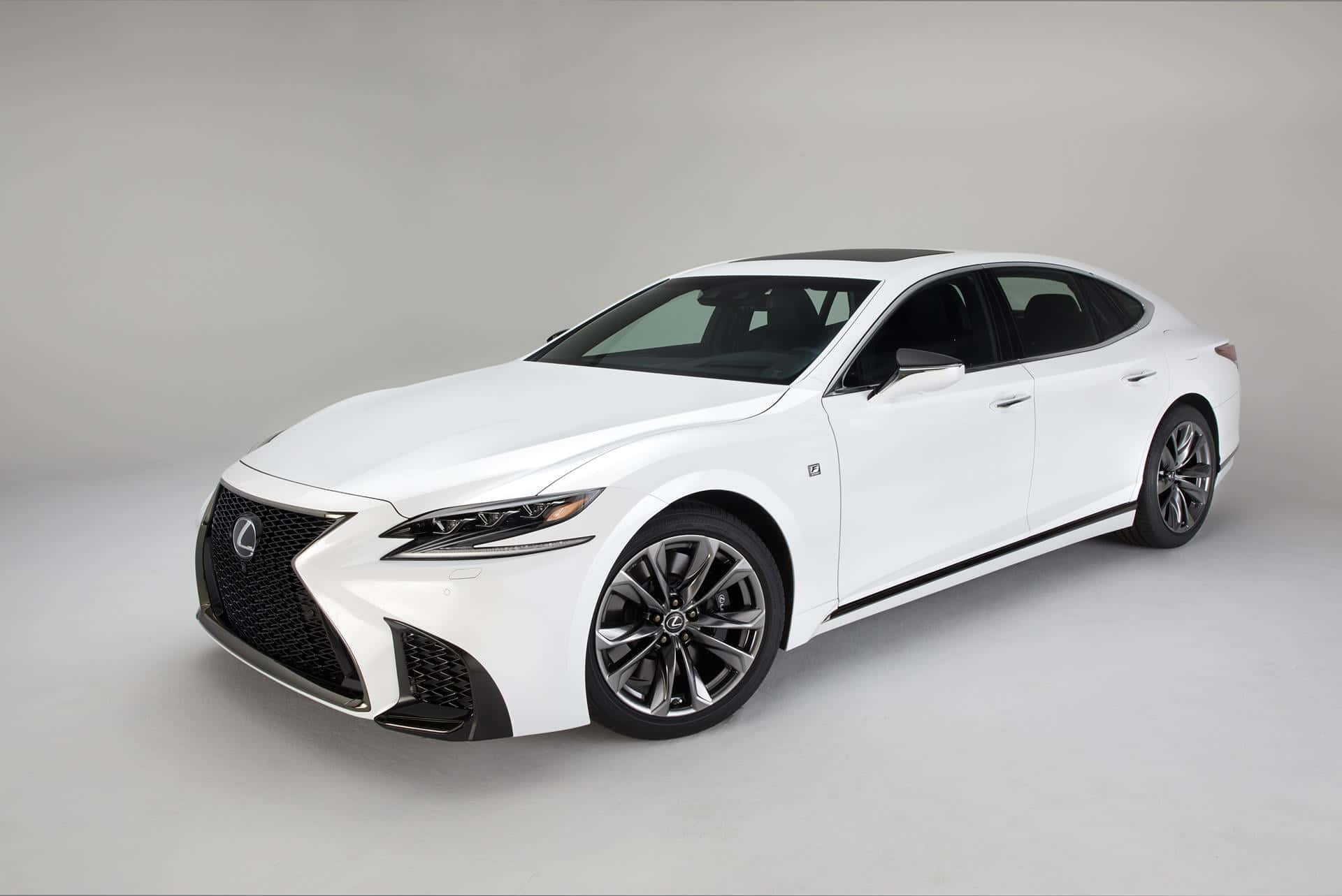 Lexus Ls 500 桌布 壁紙 — 一部純白色Lexus轎車，線條流暢，帶黑色飾邊，在簡約的攝影棚環境中展示。
