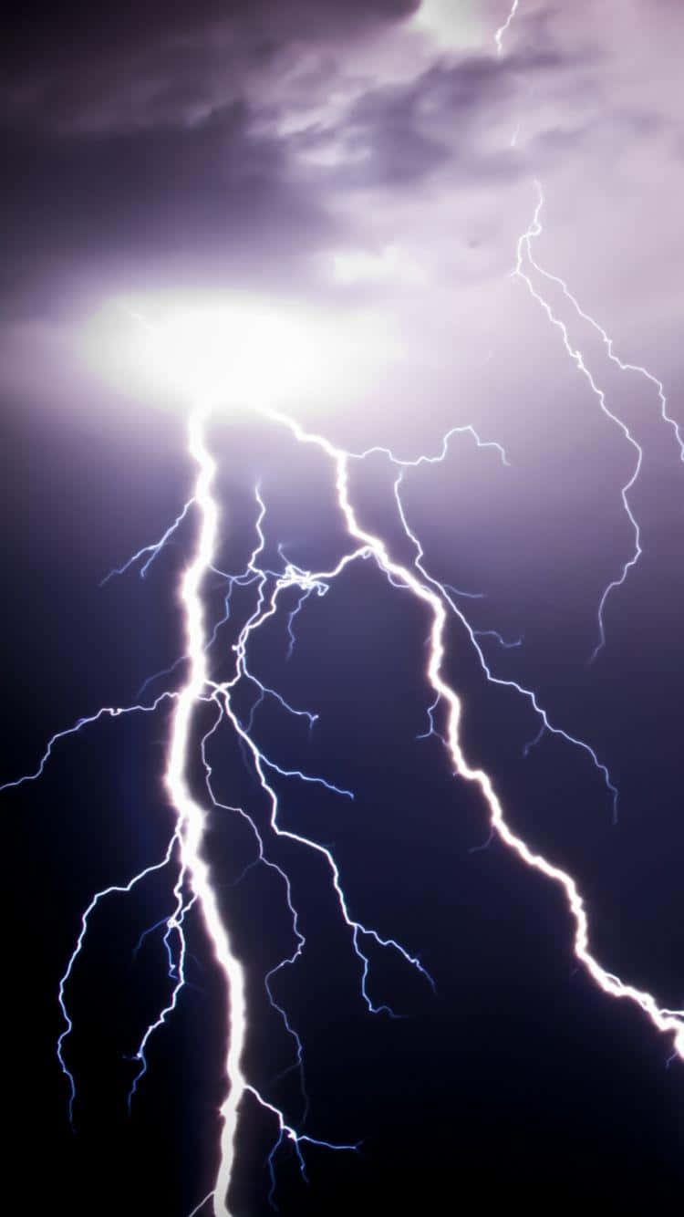 Lightning iPhone 桌布 壁紙 — 一道強大的閃電在黑暗的暴風雨天空中分叉，用電光白和藍色能量照亮紫色的雲層。