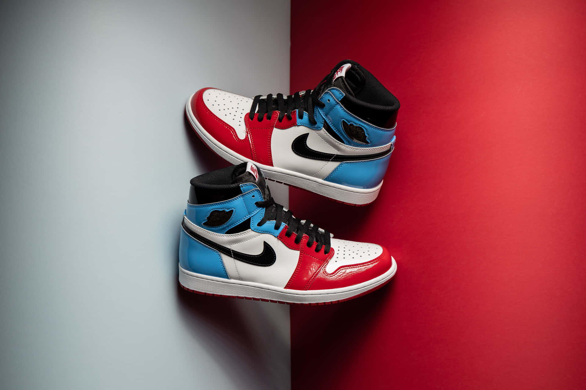 紅、藍、白色高筒運動鞋掛在紅灰分半的牆上。 — Air Jordan 壁紙