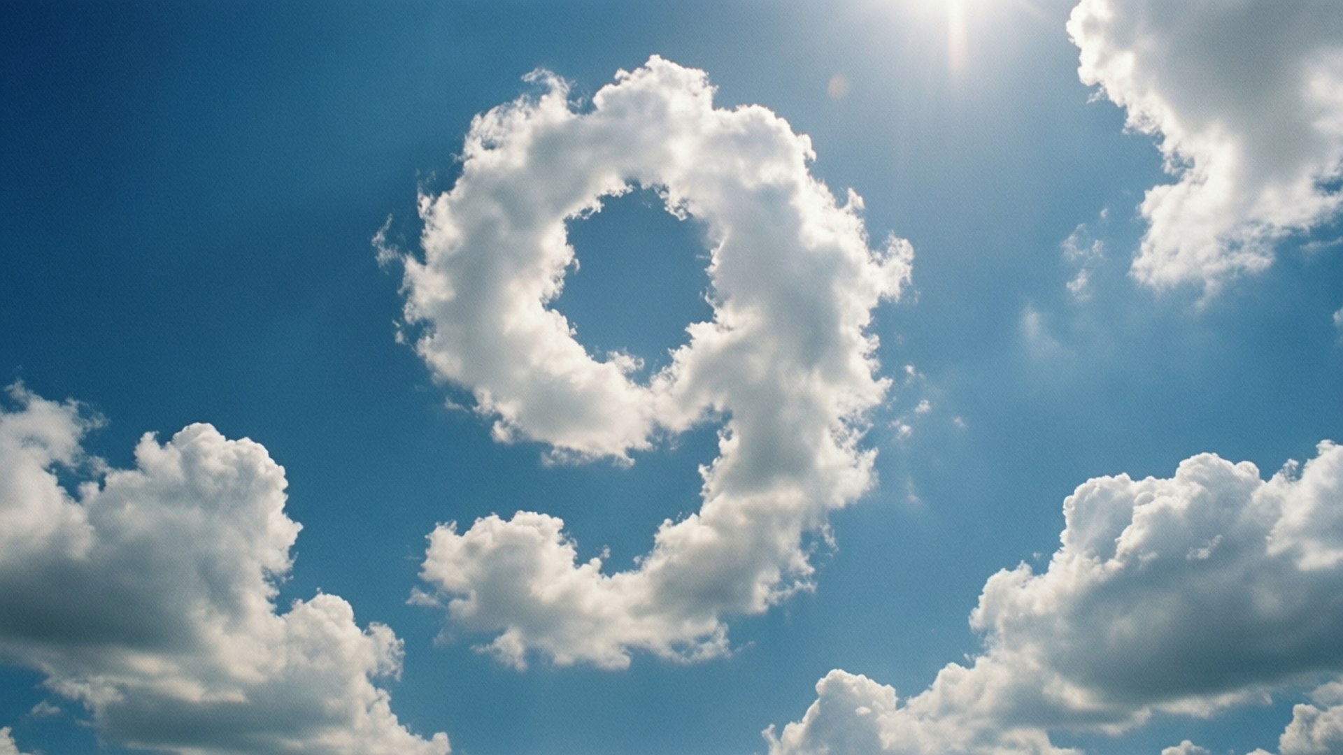 Sky Cloud Number Nine 壁紙 — 一朵蓬鬆的白雲形狀像數字九，在陽光照耀的明亮藍天上漂浮。