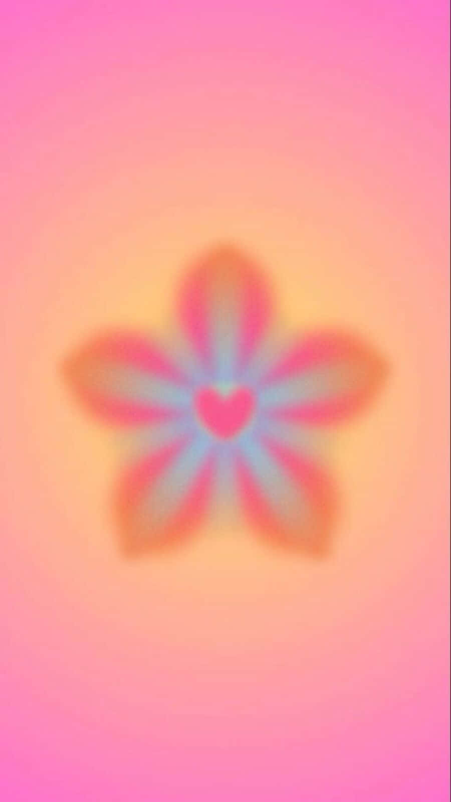  壁紙 — 一朵柔和模糊、中心為心形的花朵，在漸變背景上散發出粉紅和蜜桃色調。
