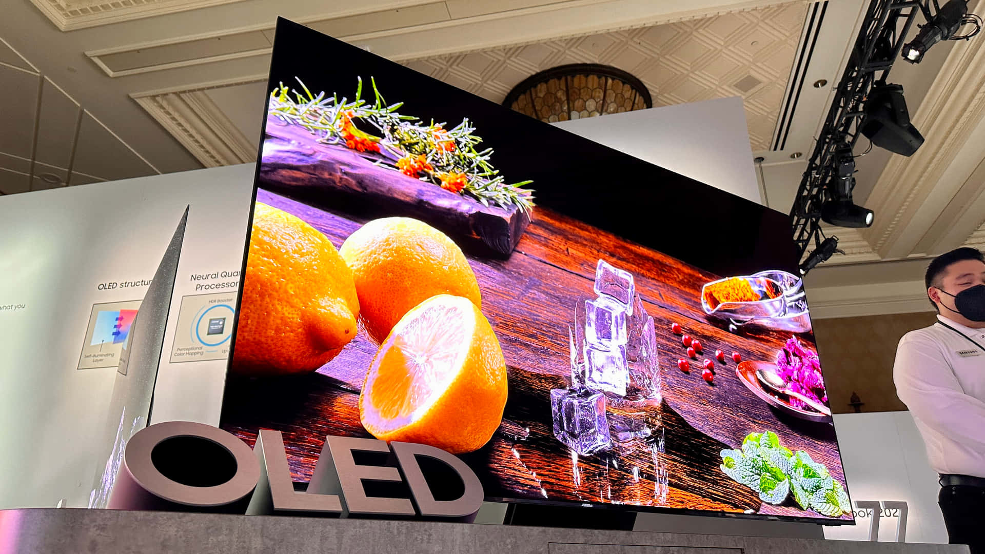 大型曲面OLED螢幕在木頭上展示新鮮橙子、冰塊和香草。 — Oled 壁紙