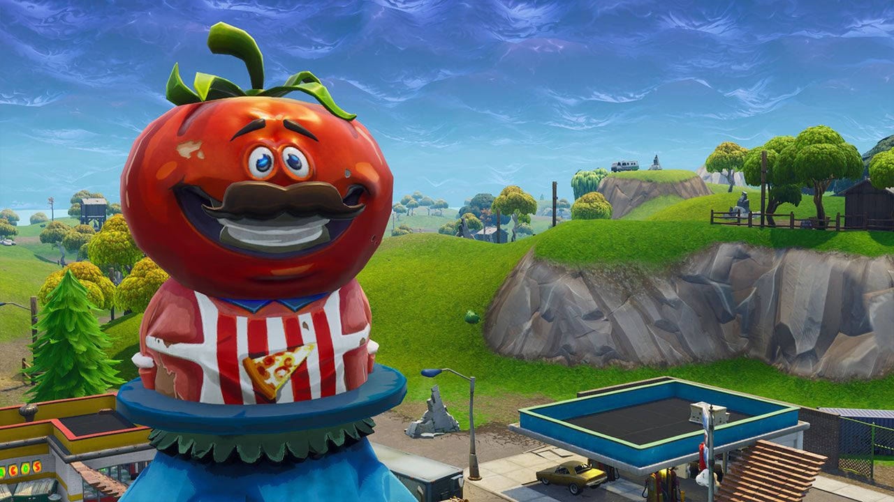在Fortnite遊戲場景中，一個巨型卡通番茄角色，背景有山丘和岩石懸崖。 — Fortnite 壁紙