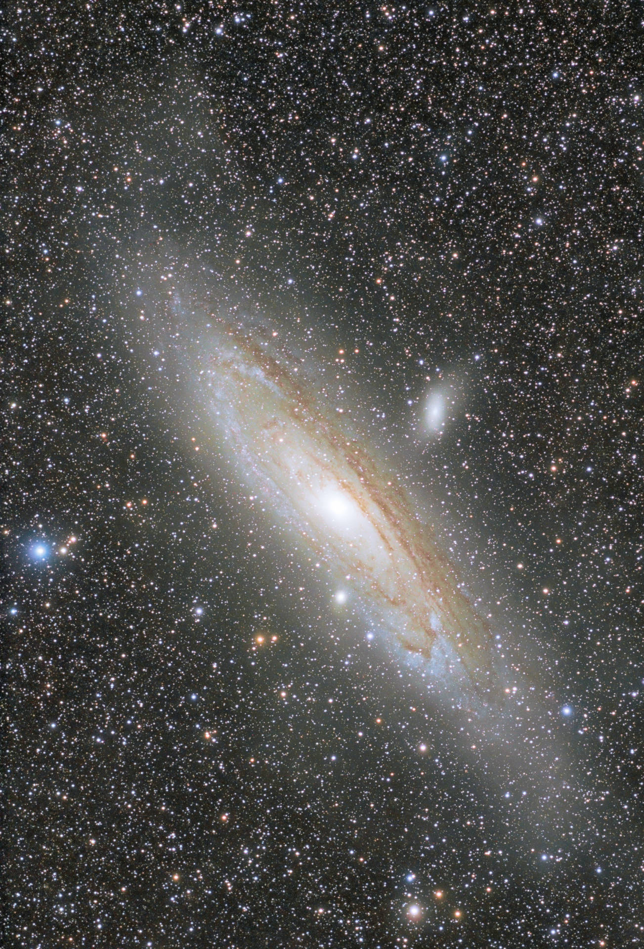 一個螺旋星系，具有明亮的核心和塵埃臂，周圍環繞著恆星 — 太空 壁紙