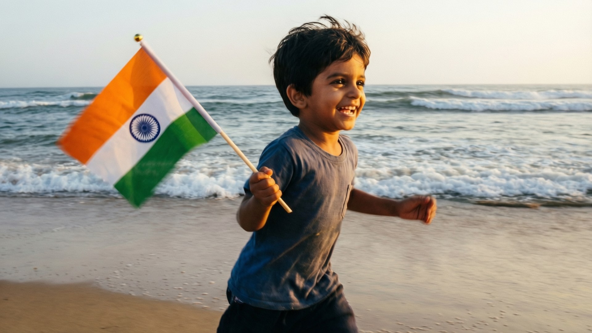 Childhood Patriotism 壁紙 — 一個快樂的印度男孩在陽光明媚的海灘上奔跑，揮舞著他的國旗，身後的海浪拍打著。