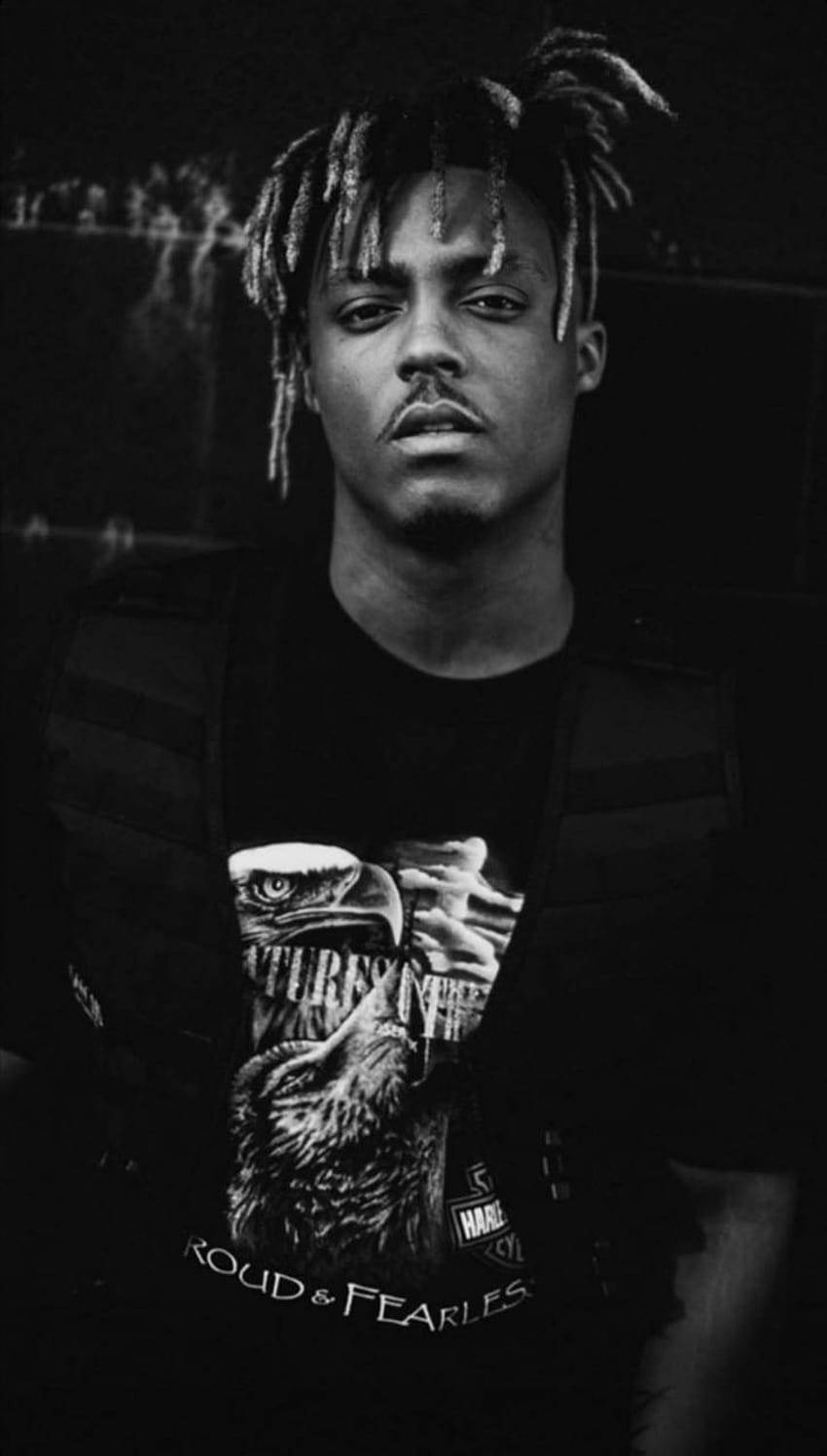 一個留著辮子頭的男人穿著背心和老鷹T恤的黑白照片。 — Juice Wrld 壁紙