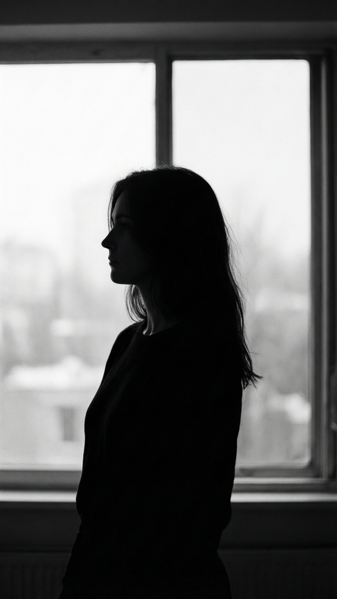 Silhouette by Window 壁紙 — 一個女人的剪影側身站在窗邊，柔和背光營造出強烈的黑白對比。