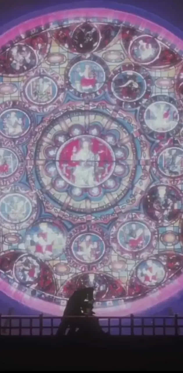  壁紙 — 一個人的剪影站在一個巨大的、發光的玫瑰窗前，投射出鮮豔的彩色玻璃圖案。