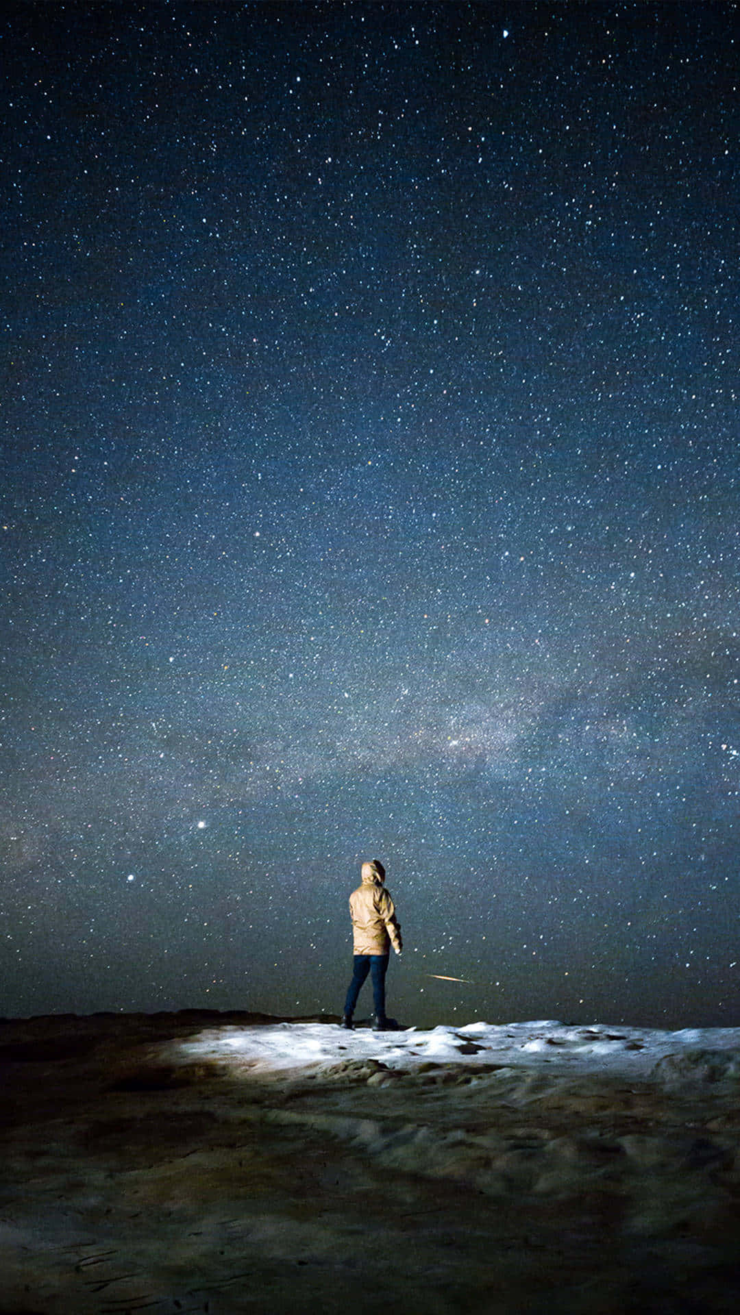  壁紙 — 一個人獨自站在白雪覆蓋的山丘上，頭頂是廣闊的星空，銀河在閃耀。