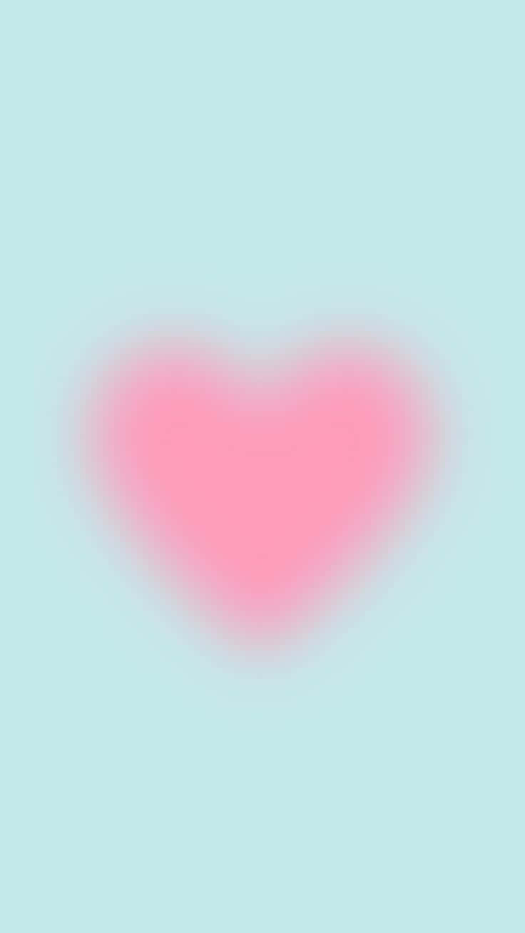 Pink Heart Aura 桌布 壁紙 — 一個柔和的粉紅色心形，帶有發光漸變，輕輕漂浮在淡薄荷綠背景上。