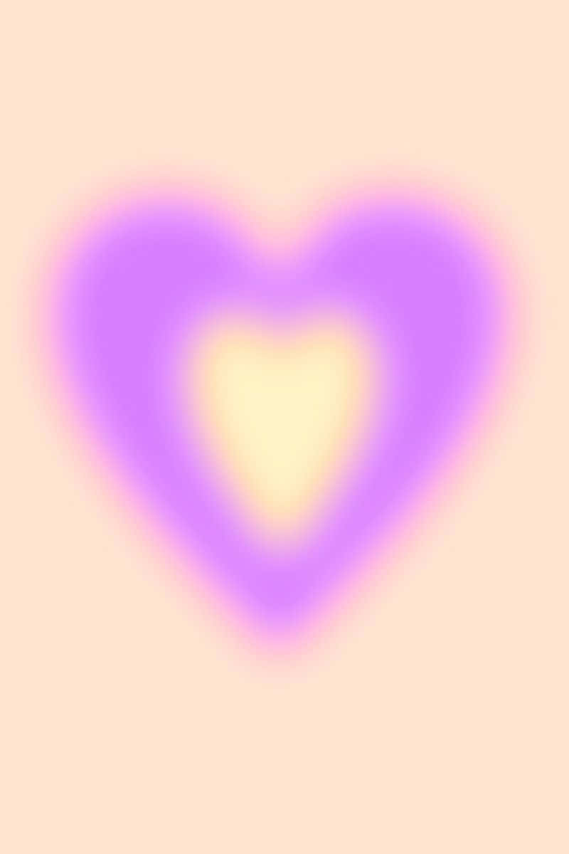 Pink Heart Aura 桌布 壁紙 — 一個柔和發光的心形，帶有紫色外層光暈和黃色內核，置於淡蜜桃色背景上。