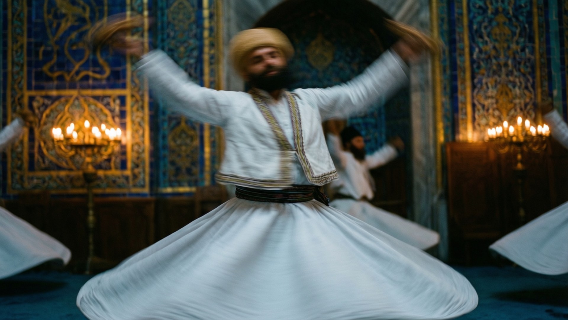 Whirling Dervish Ceremony 壁紙 — 一個旋轉的苦行僧穿著白色長袍，在燭光照耀下華麗的藍色牆壁前旋轉。